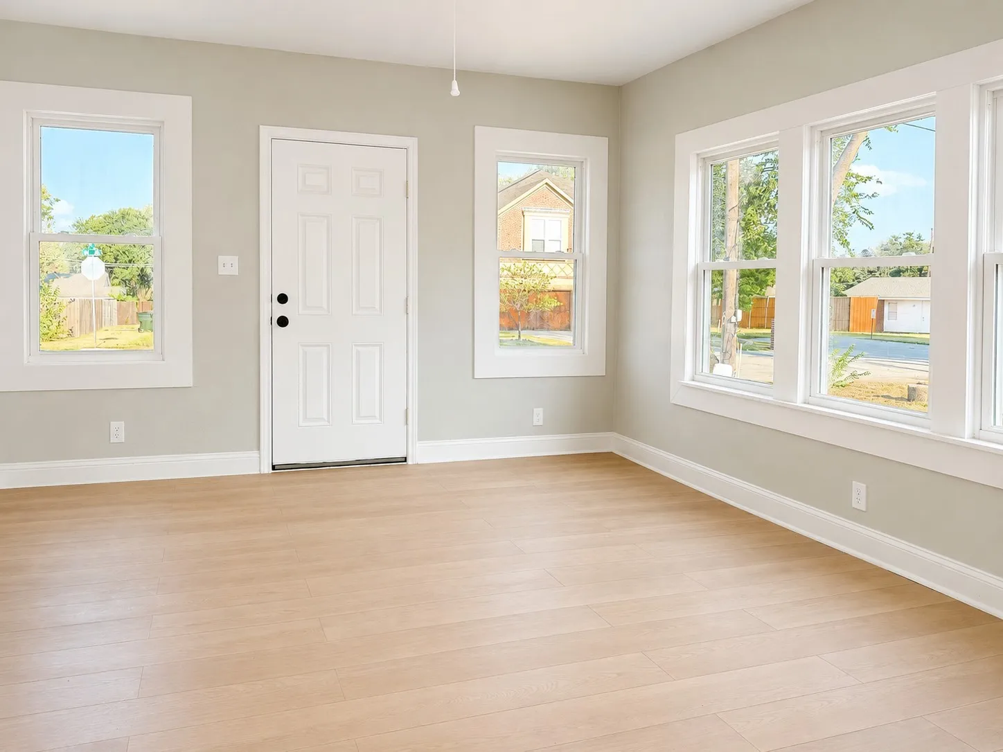 Neutral wall tones, wood-finish flooring, white trim, and multiple windows