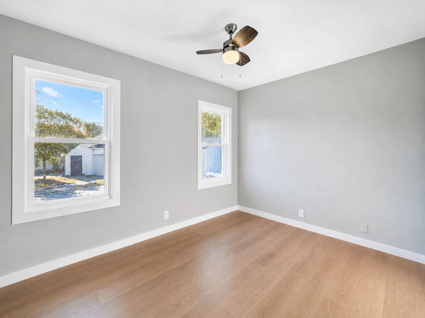 Light-colored walls, wood-finish flooring, and multiple windows create a bright interior