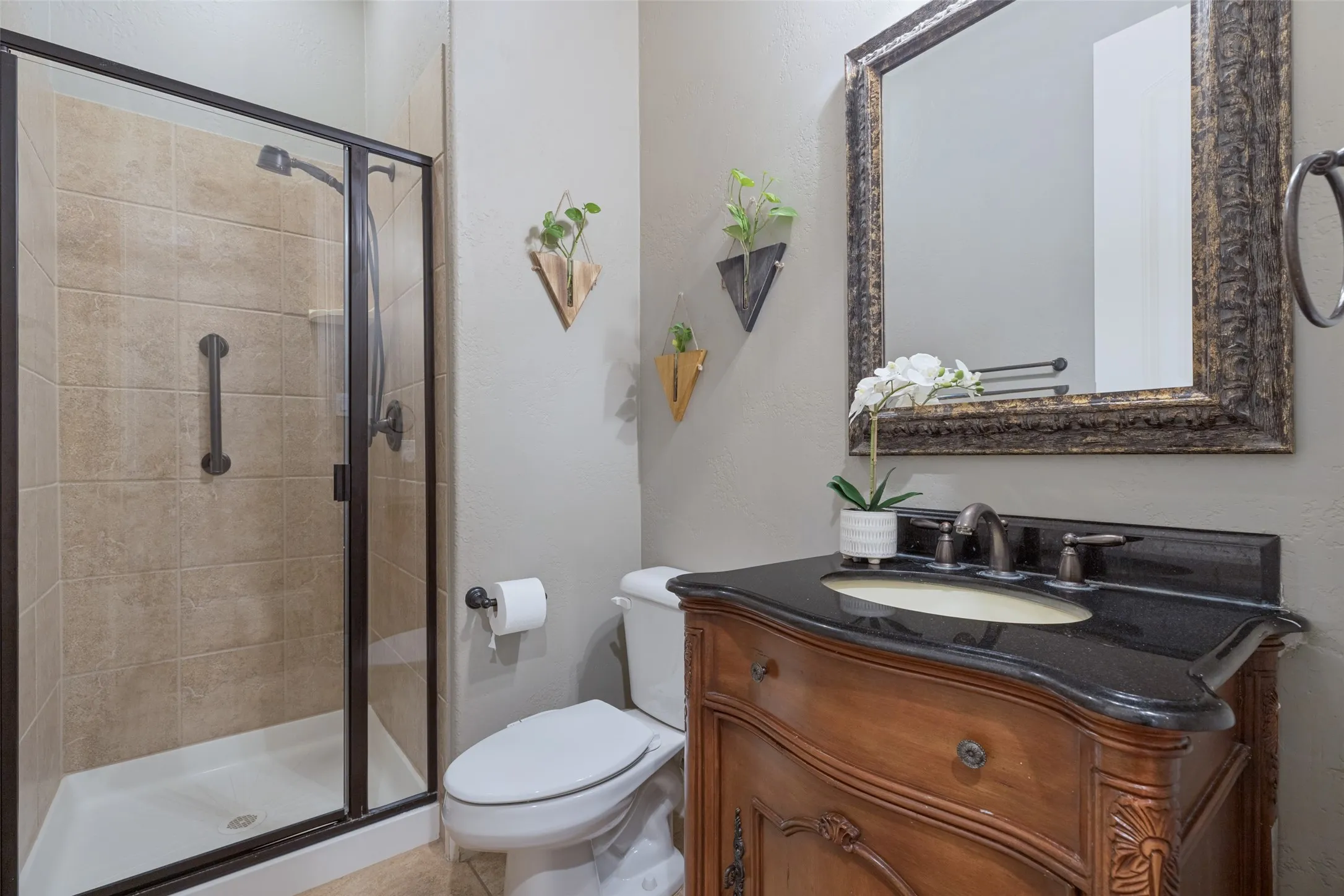Walk-in shower with tile surround and dark bronze frame