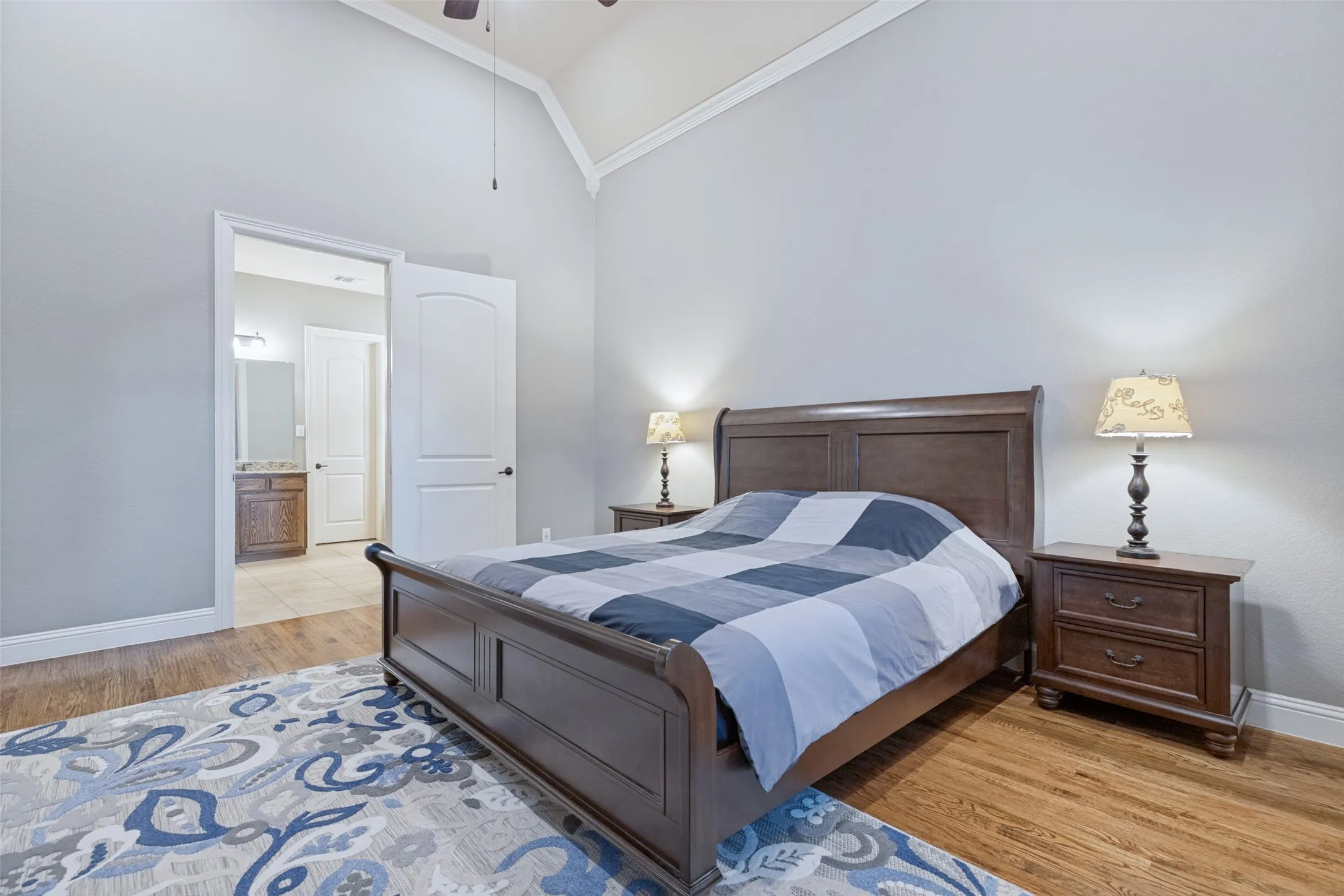 Vaulted ceiling, wood-finish flooring, and arched doorways