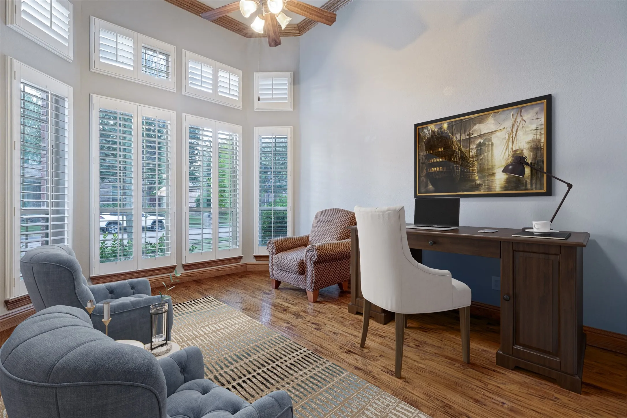 High ceilings with exposed wood beams, wood-finish flooring, multiple windows with white plantation shutters, and a built-in ceiling fan with lighting