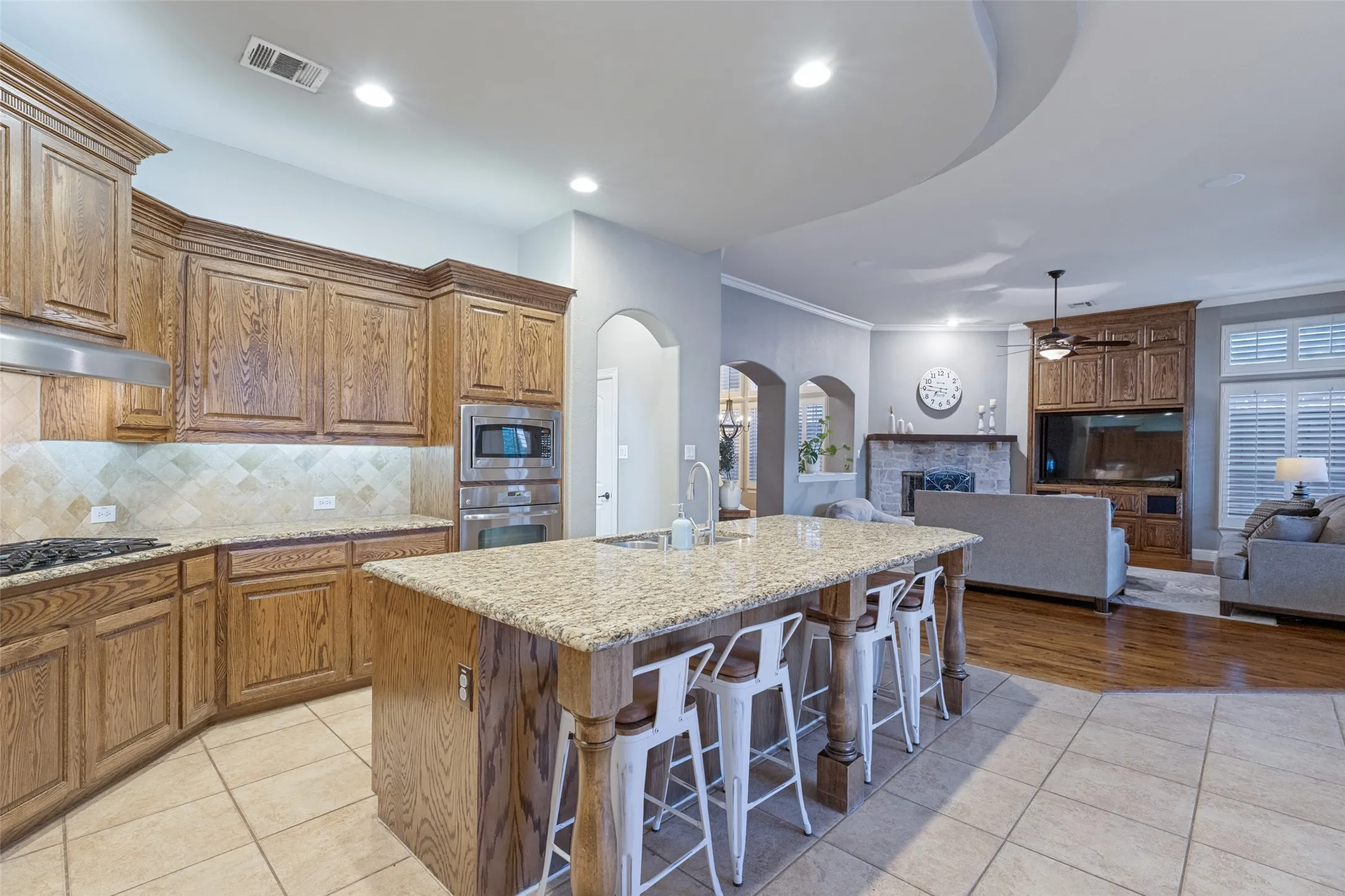Kitchen featuring a center island with bar seating, integrated stainless steel appliances, and wood-finish cabinetry