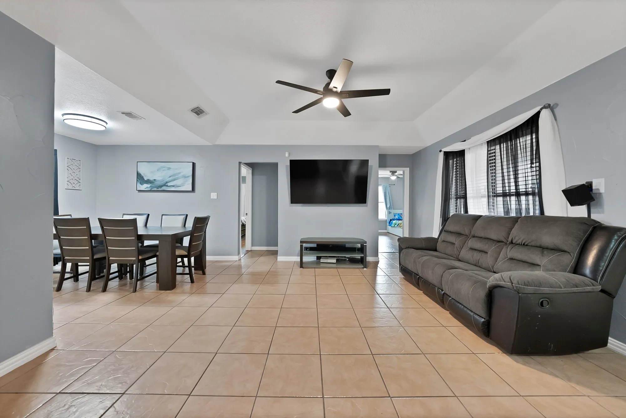 Vaulted ceiling with ceiling fan, recessed lighting, tile flooring, and light gray wall paint