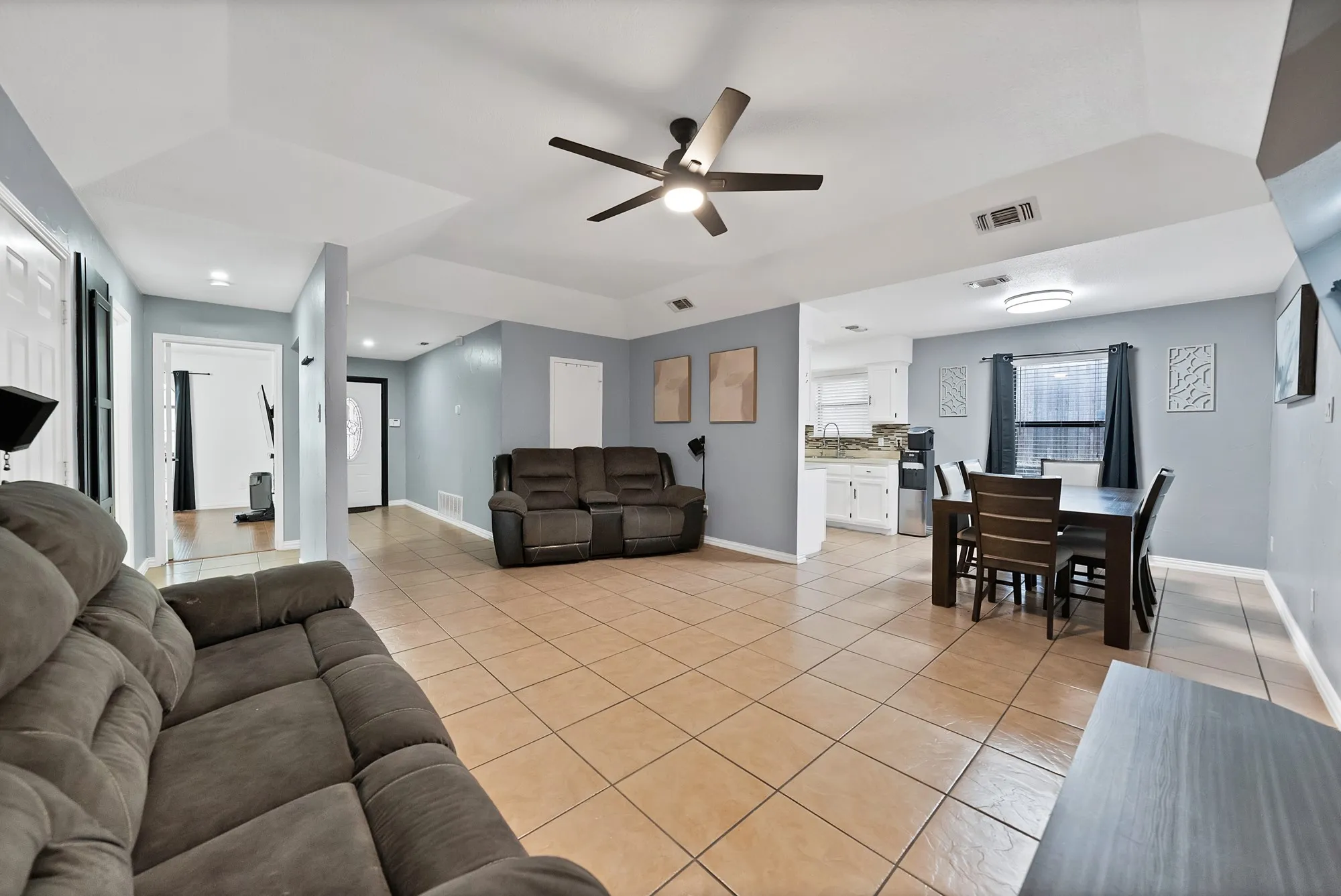 Open-concept living space with tile flooring, a ceiling fan, and recessed lighting