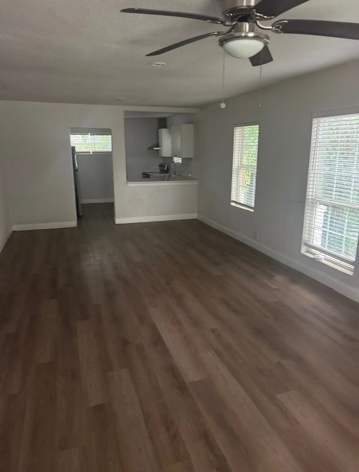 Open concept living area featuring wood-finish flooring, recessed lighting, and a ceiling fan with integrated light