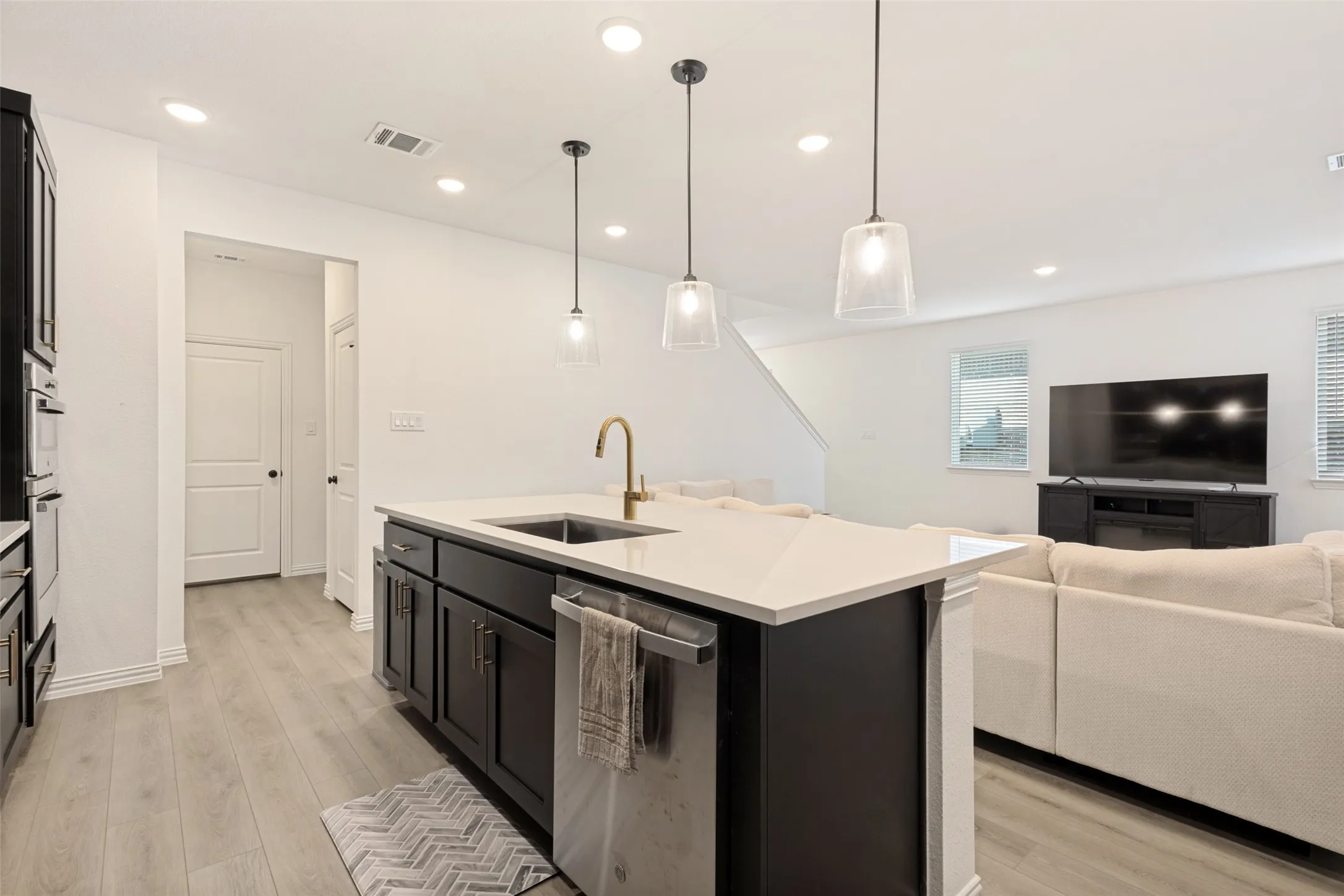 Central kitchen island with a built-in sink and gold-tone faucet