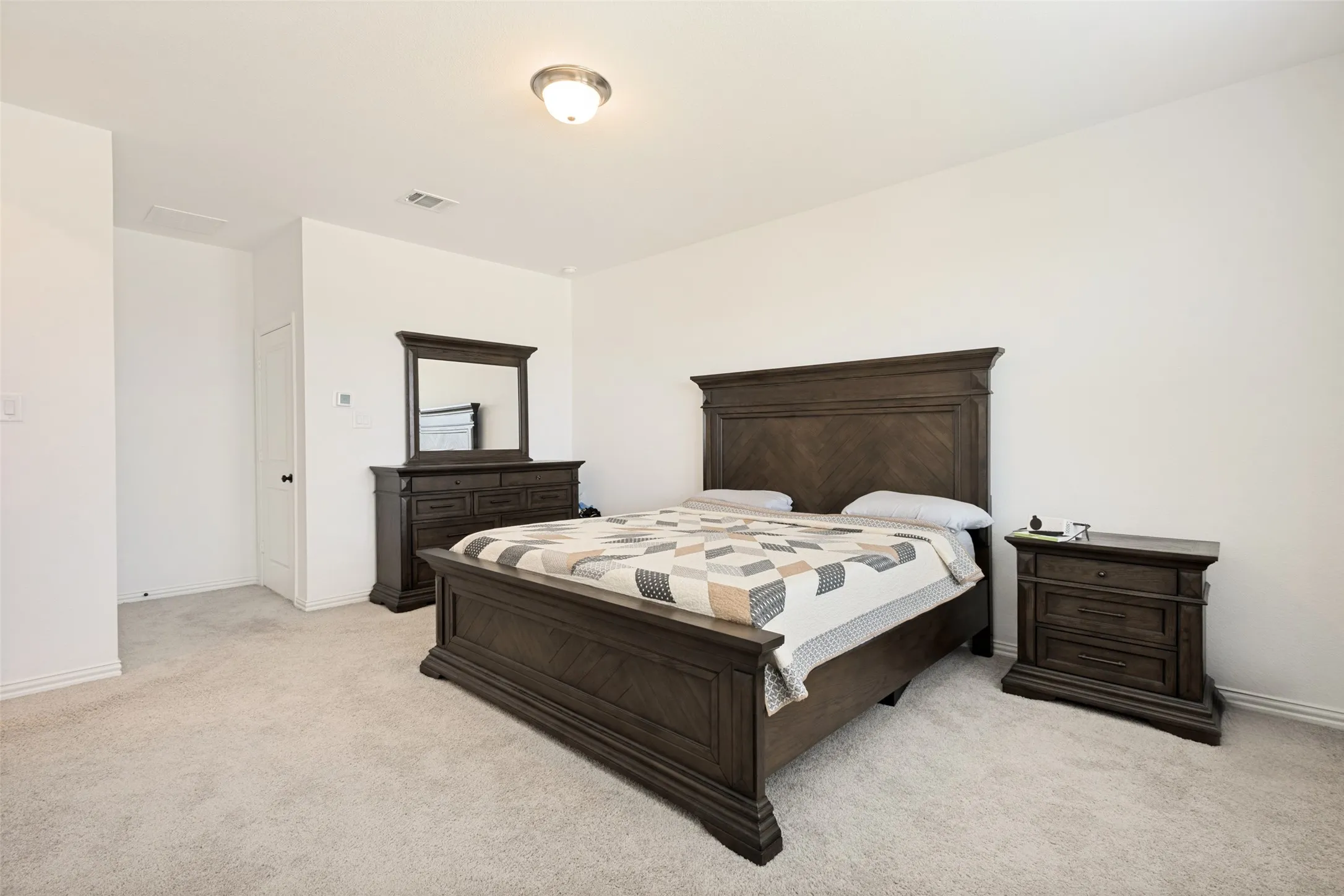 Recessed ceiling light fixture, neutral wall finishes, and light-colored carpet flooring