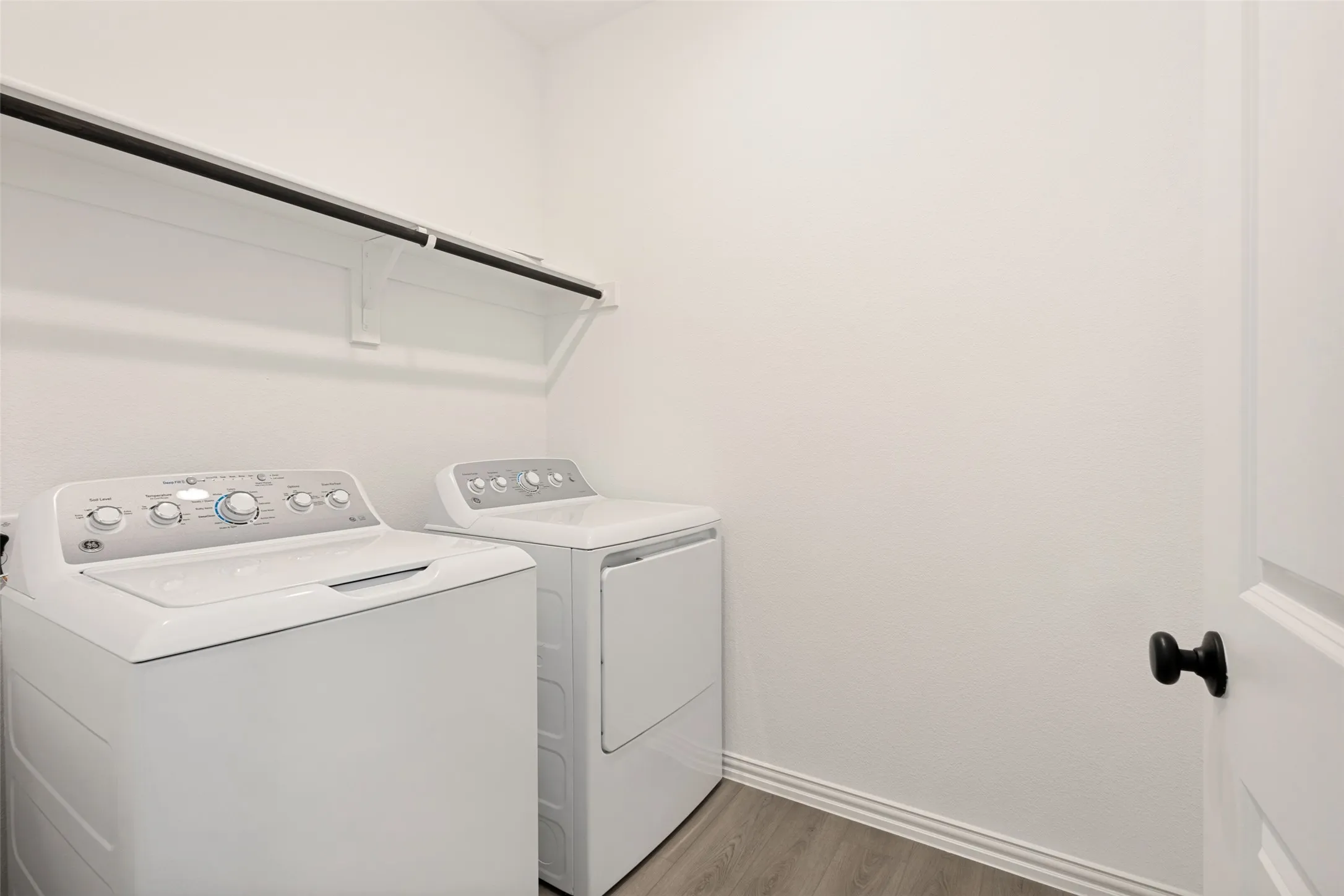 Built-in shelving with a hanging rod and wood-finish flooring