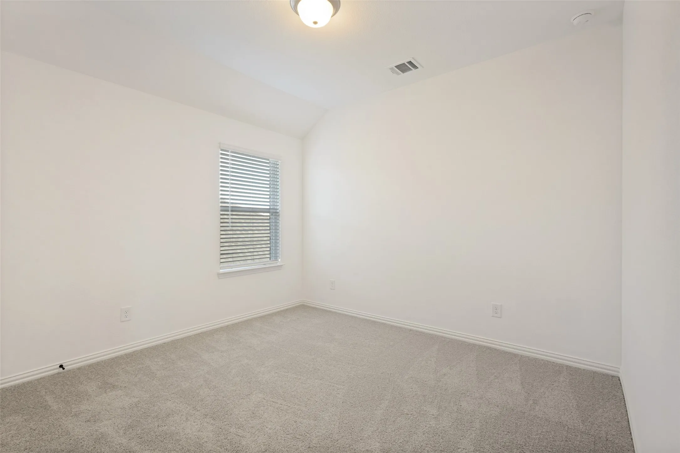 Carpeted flooring with a neutral finish, white walls, and a single window with blinds