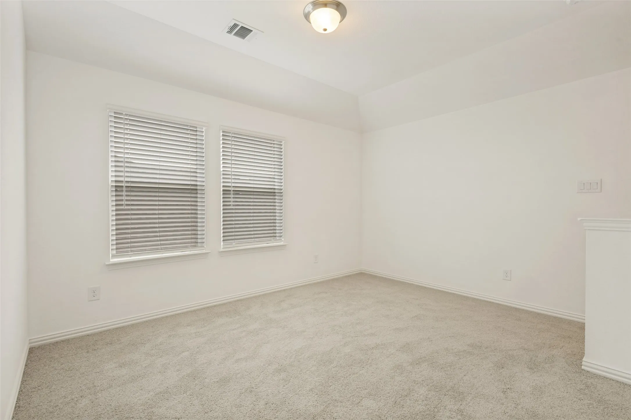 Neutral wall colors, twin windows with blinds, recessed ceiling, and a flush mount lighting fixture