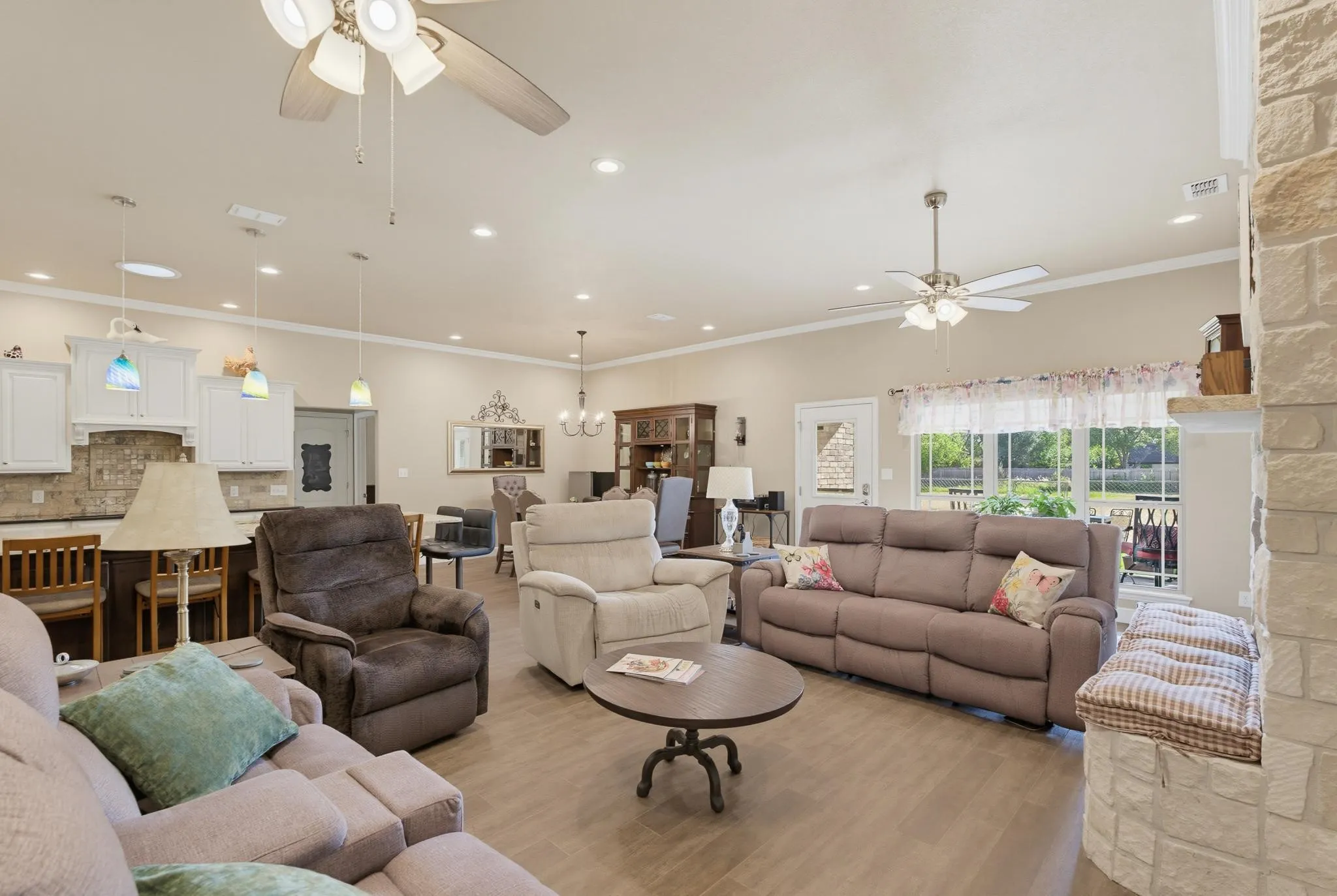 Open-concept living area featuring wood-finish flooring, recessed lighting, and ceiling fans