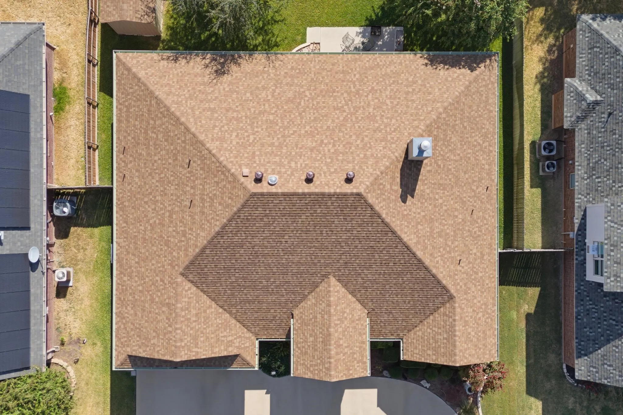 Gable roof design with asphalt shingles, featuring multiple roof vents and a chimney