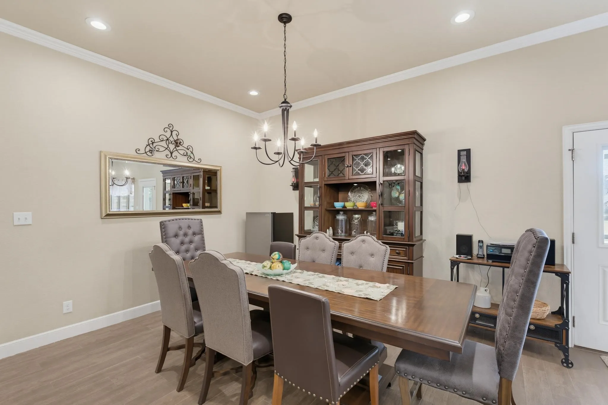 Vaulted ceiling with crown molding, recessed lighting, wood-finish flooring, and a chandelier