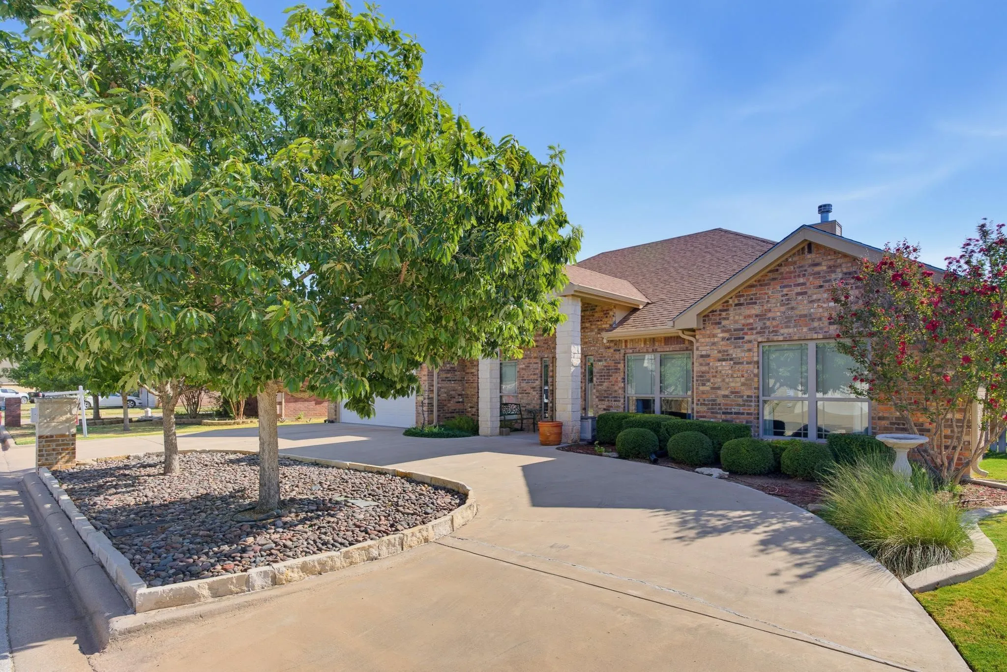 Brick exterior with a gabled roof and a concrete driveway
