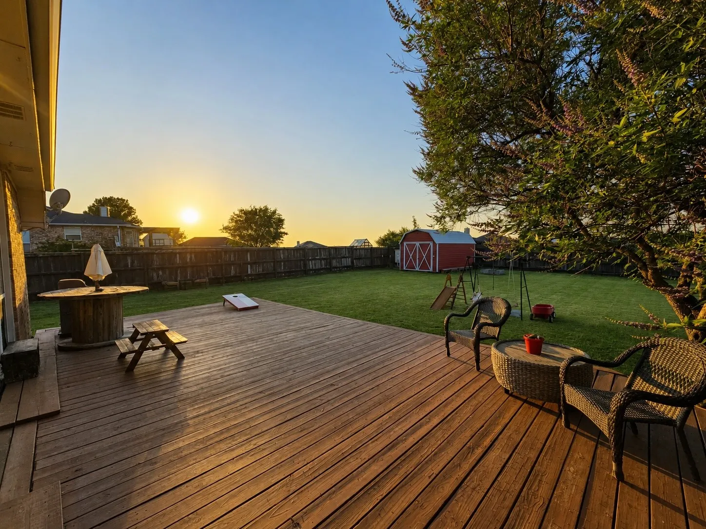 Expansive wood deck overlooking a manicured lawn