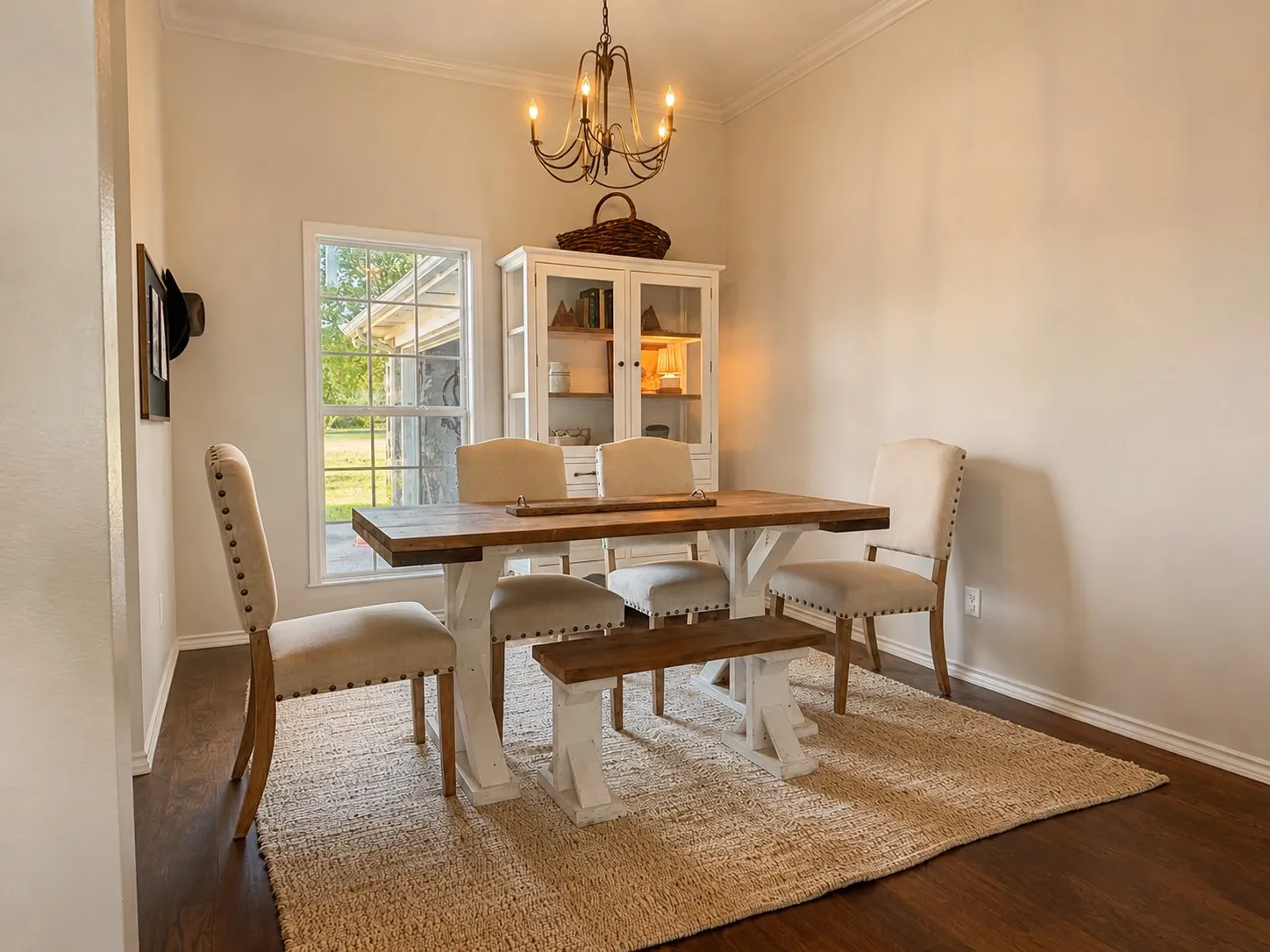 Dining area featuring wood-finish flooring, crown molding, a window with exterior views, and a prominent built-in display cabinet