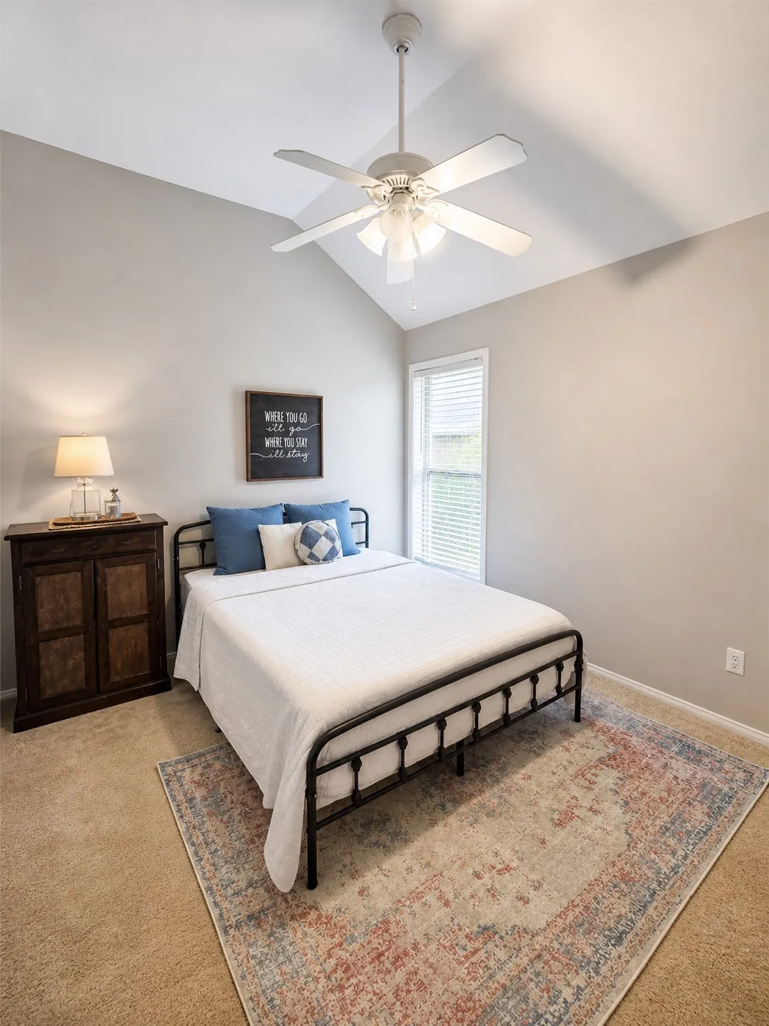 Vaulted ceiling featuring a ceiling fan with integrated lighting, a single window with blinds, and neutral wall paint