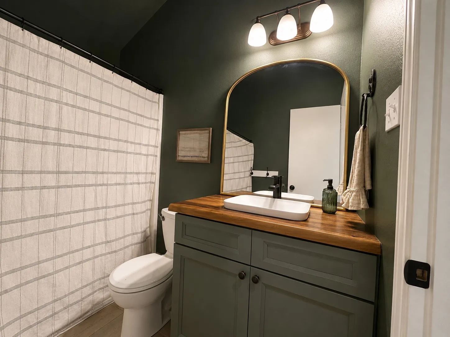 Bathroom vanity featuring a wood-finish countertop, a rectangular vessel sink, and a matte black faucet