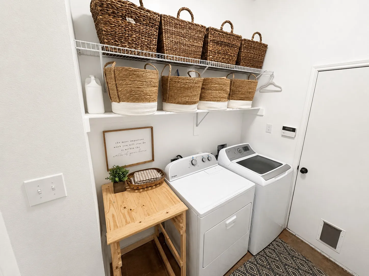Dedicated laundry area featuring white walls and a white door