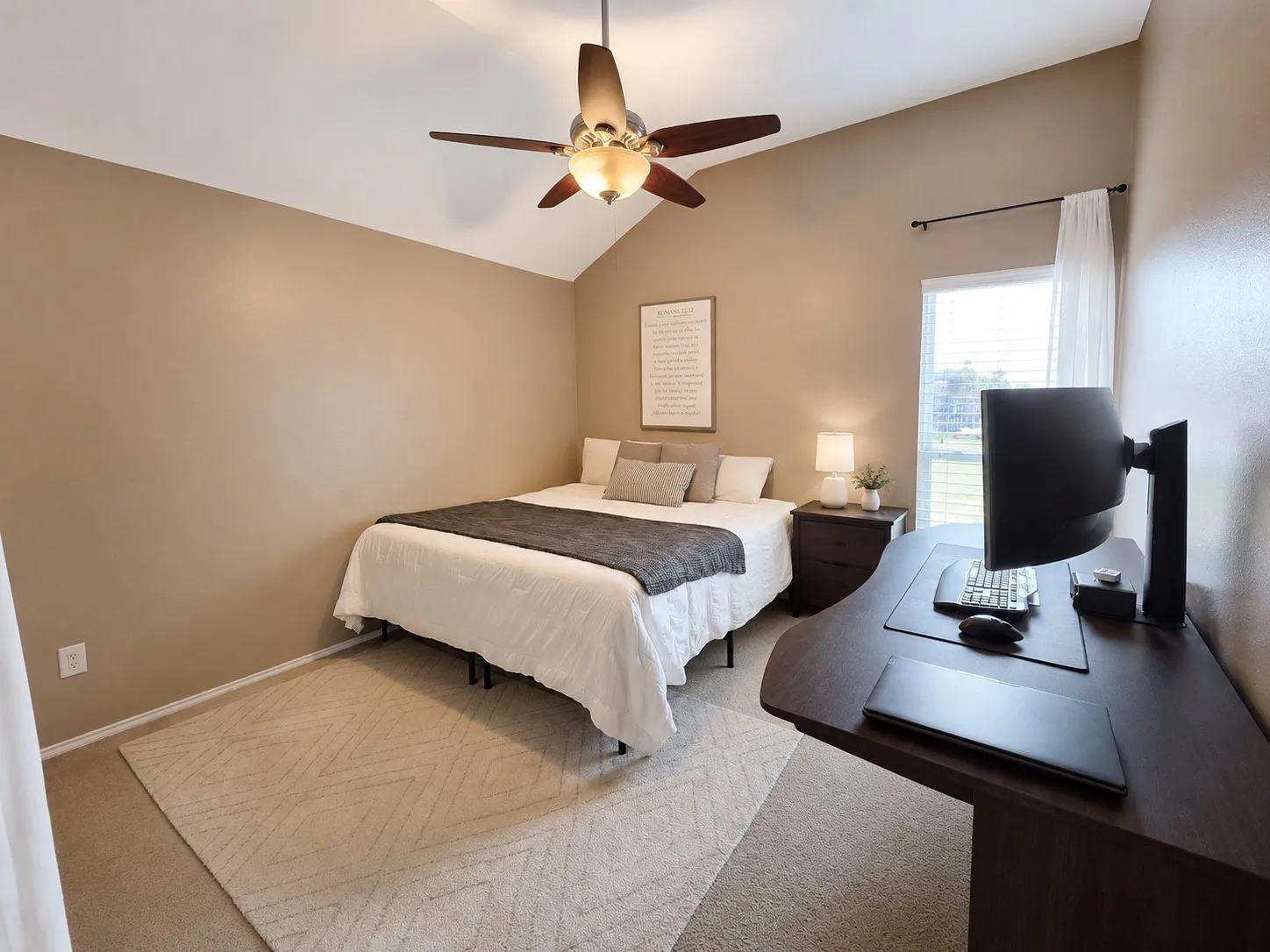 Vaulted ceiling bedroom featuring a ceiling fan with integrated lighting, a window with blinds and sheer curtains, and neutral-toned wall paint