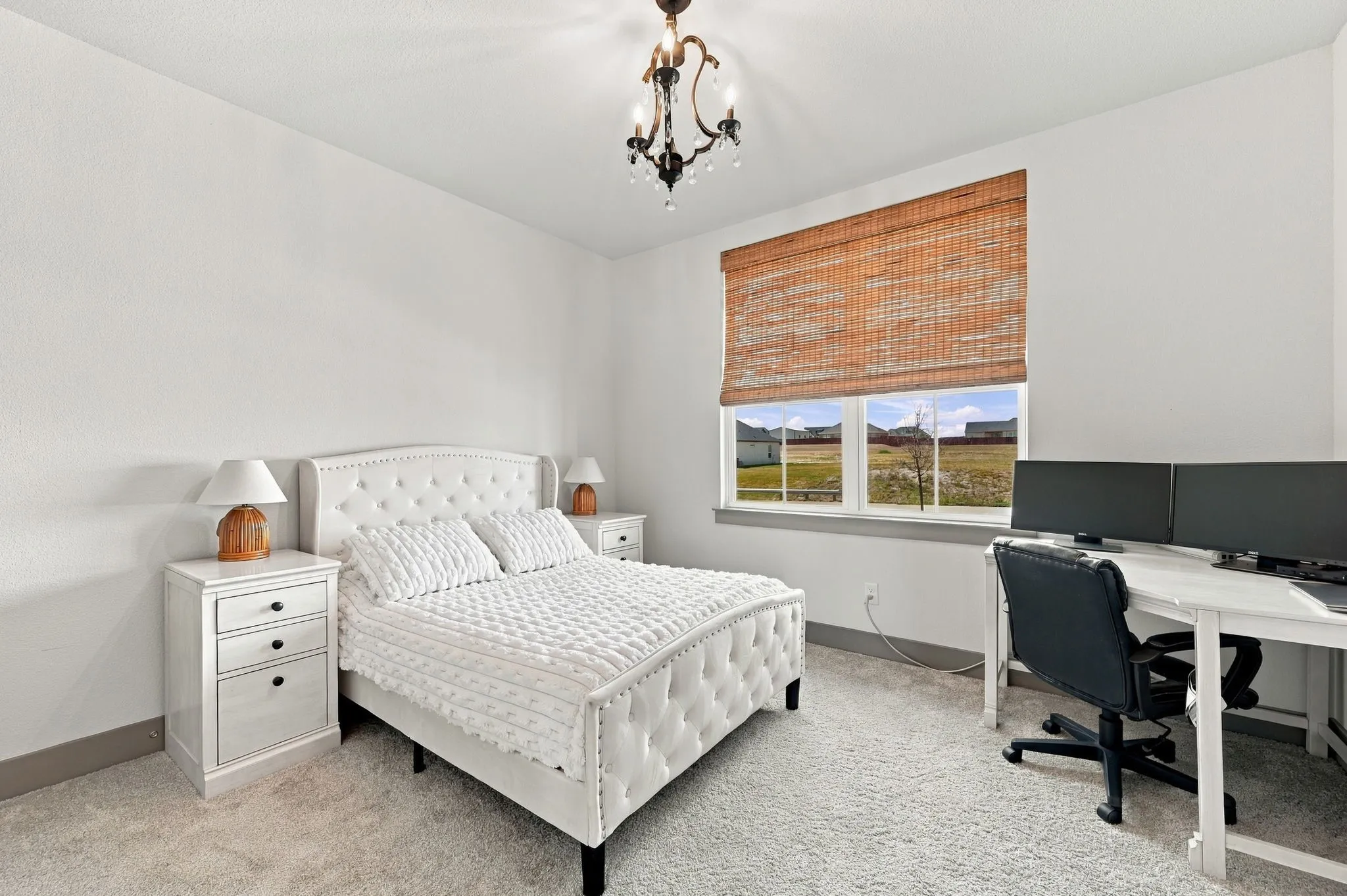 White walls with textured finish, light-colored carpet, and a decorative chandelier