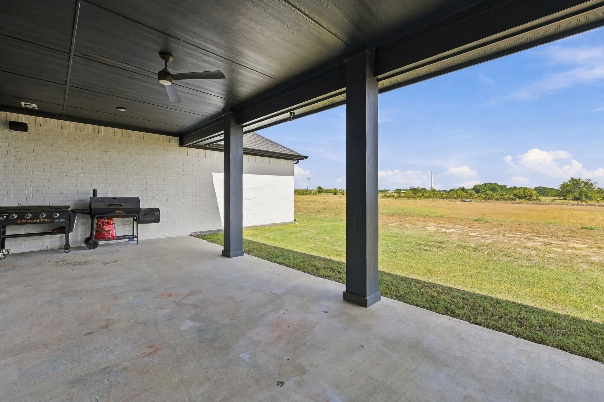 Covered patio with a concrete surface, ceiling fan, recessed lighting, and brick exterior wall