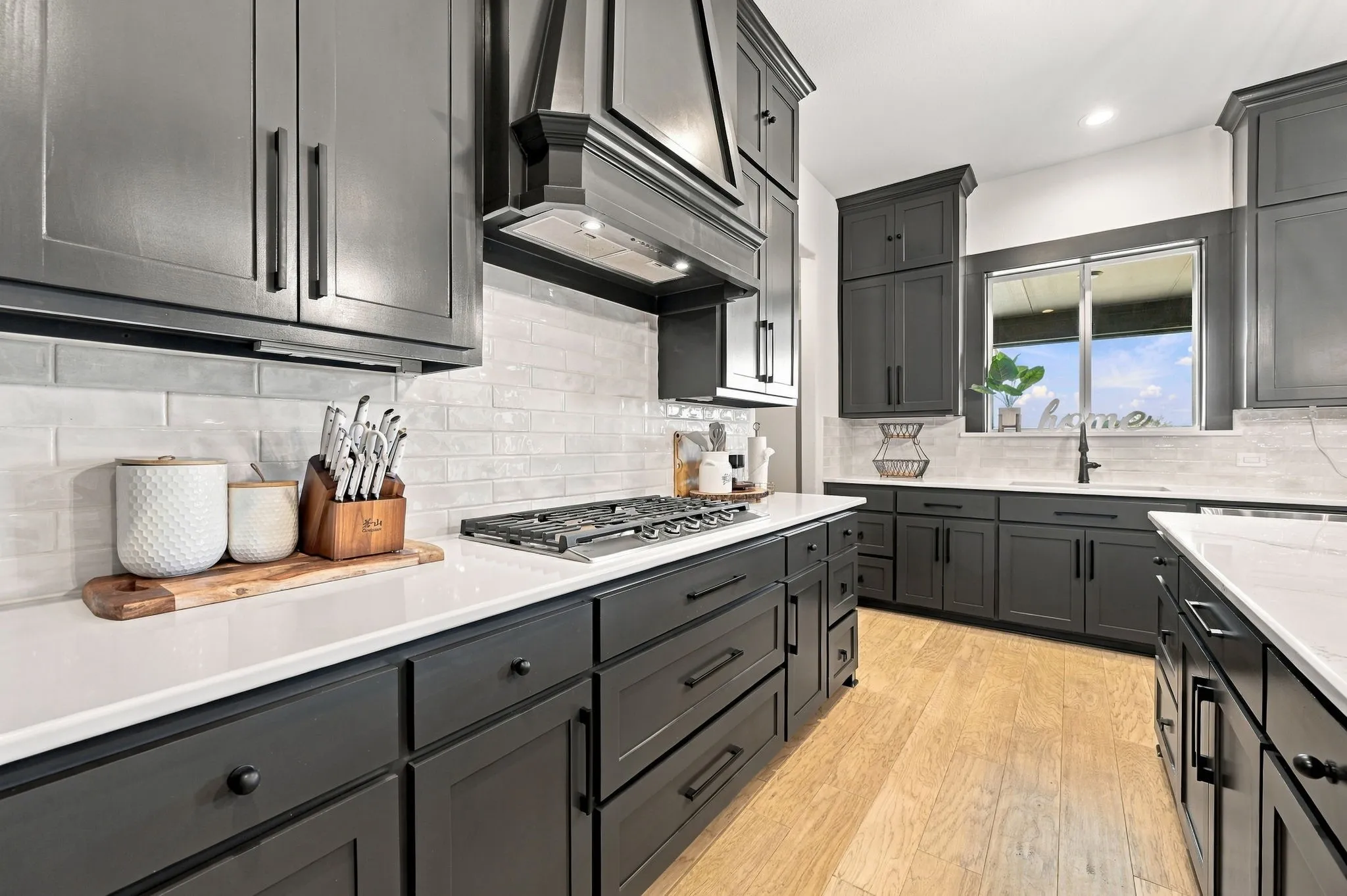 Kitchen featuring dark shaker-style cabinetry, white countertops, a gas cooktop, and a subway tile backsplash
