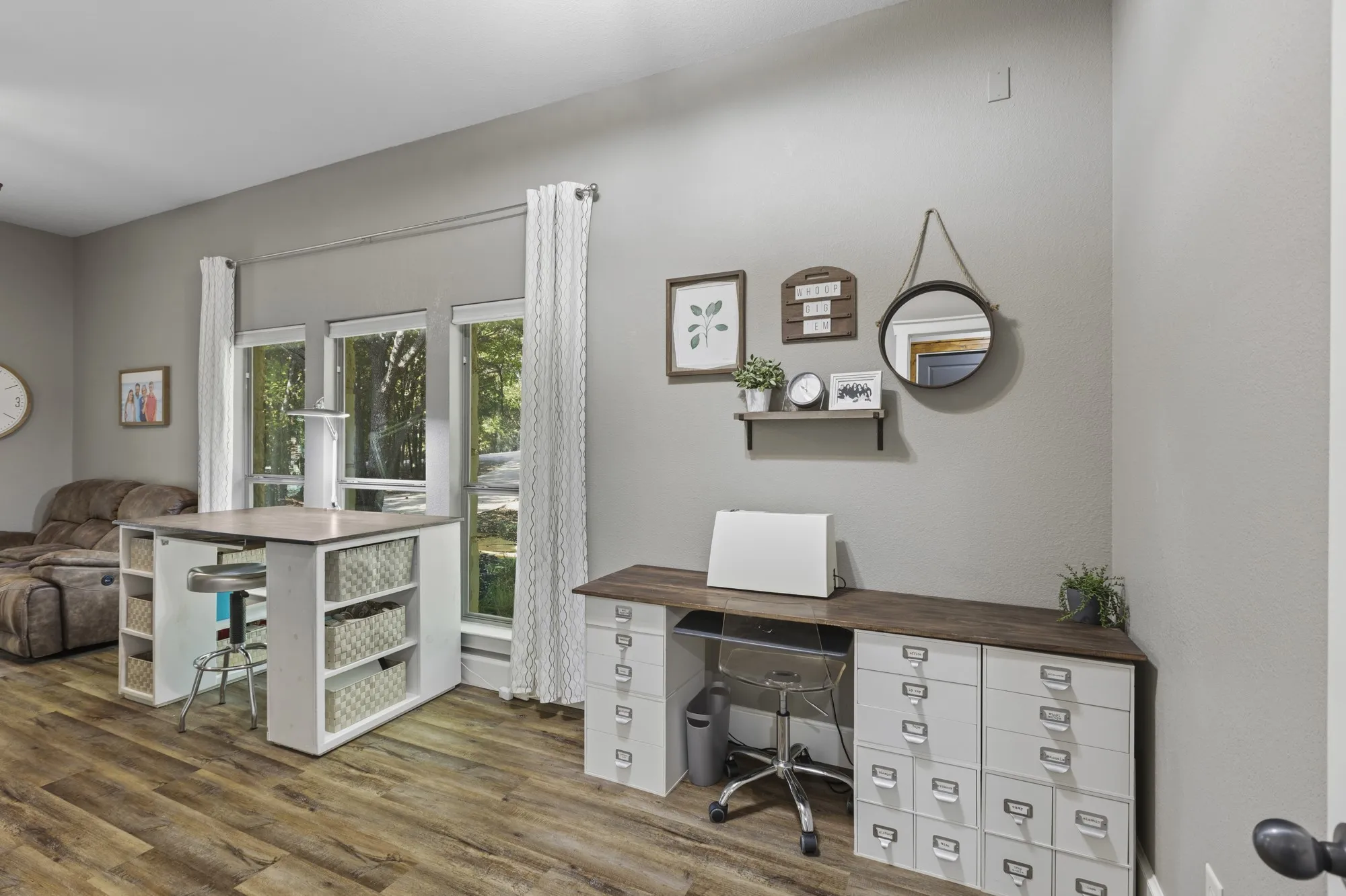 Wood-finish flooring, light grey wall paint, and multiple windows with white trim