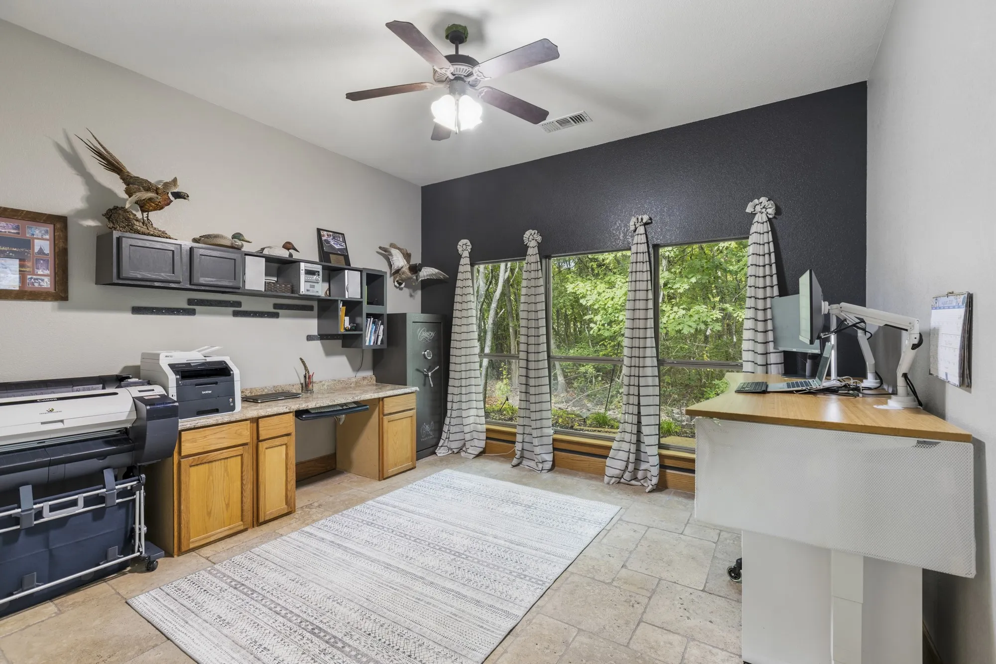 Vaulted ceiling with a ceiling fan, built-in cabinetry with a countertop, window wall, and tile flooring