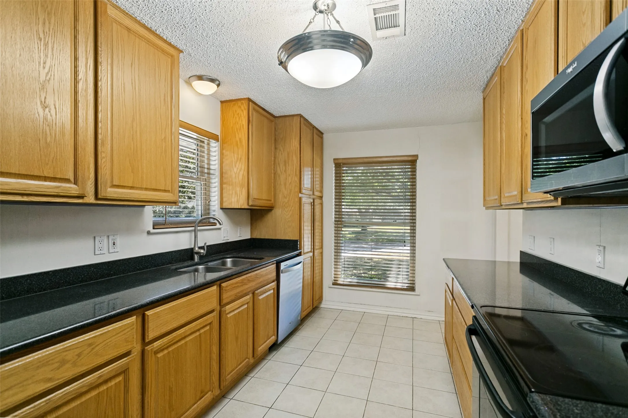 Wood cabinetry and dark countertops