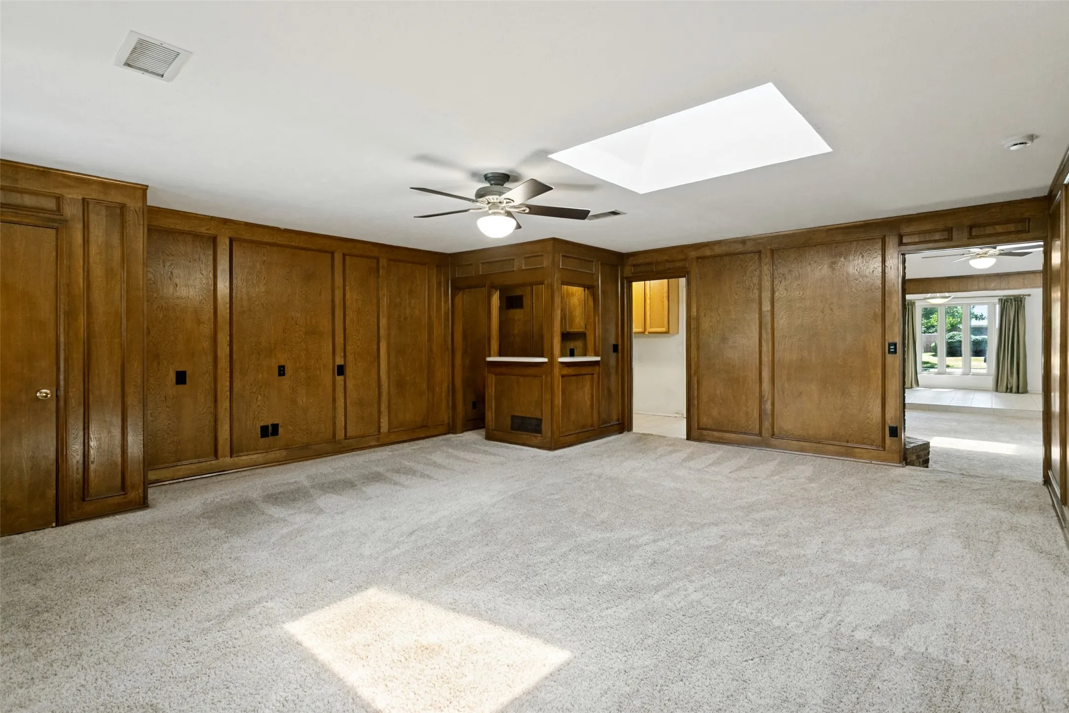 Warm wood paneling, built-in cabinetry, and a skylight
