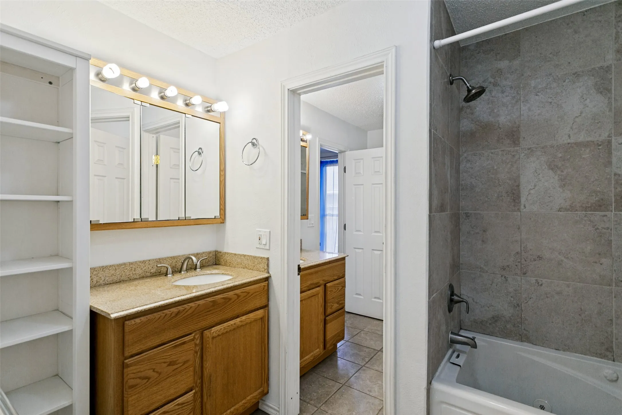 Bathroom featuring a built-in vanity with a light-colored countertop, integrated sink, and wood-finish cabinetry