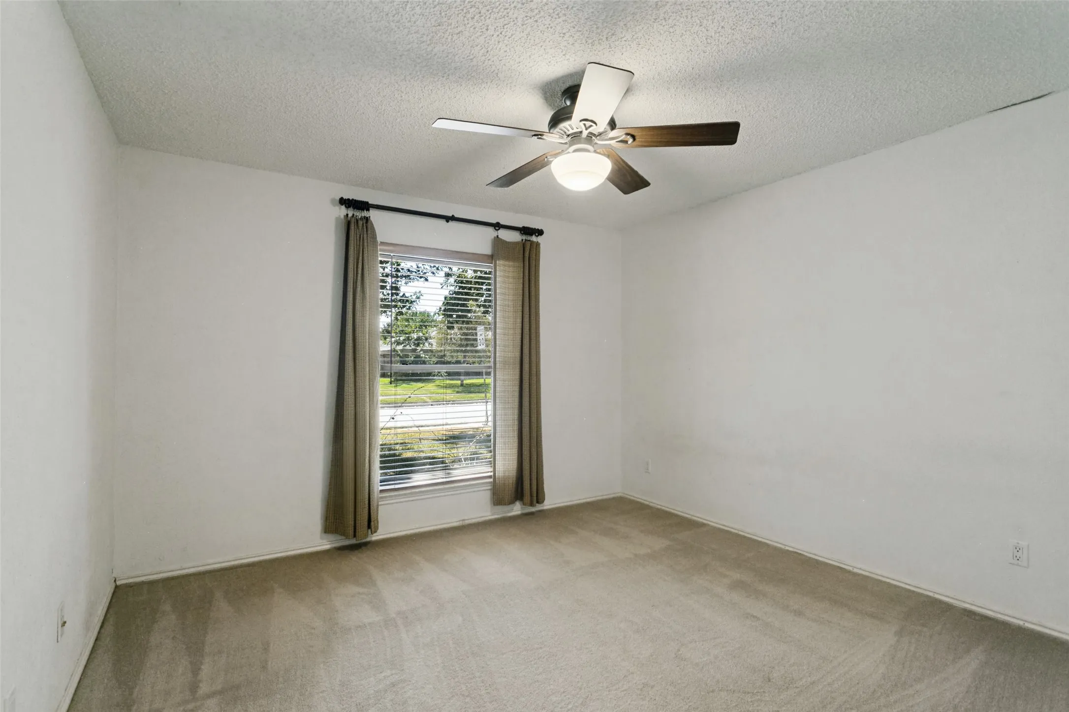 Window with horizontal blinds and drapes, ceiling fan with light fixture, and carpeted flooring