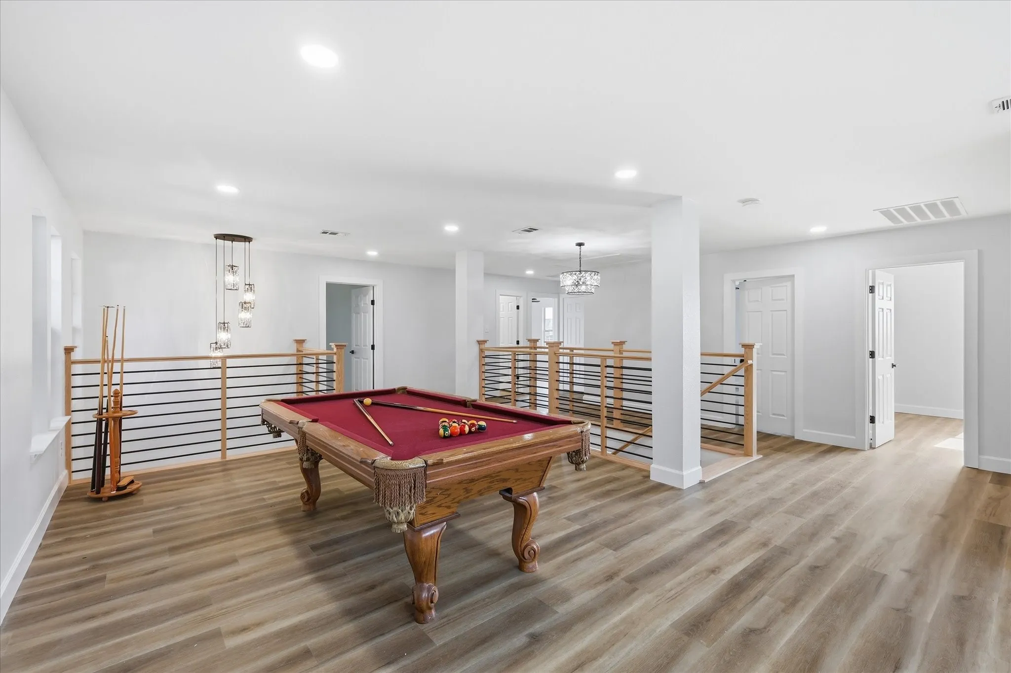 Spacious open concept room featuring wood-finish flooring, recessed lighting, and a modern chandelier