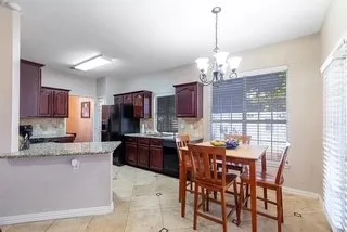 Kitchen featuring a chandelier, a peninsula, healthy amount of natural light, and freestanding refrigerator