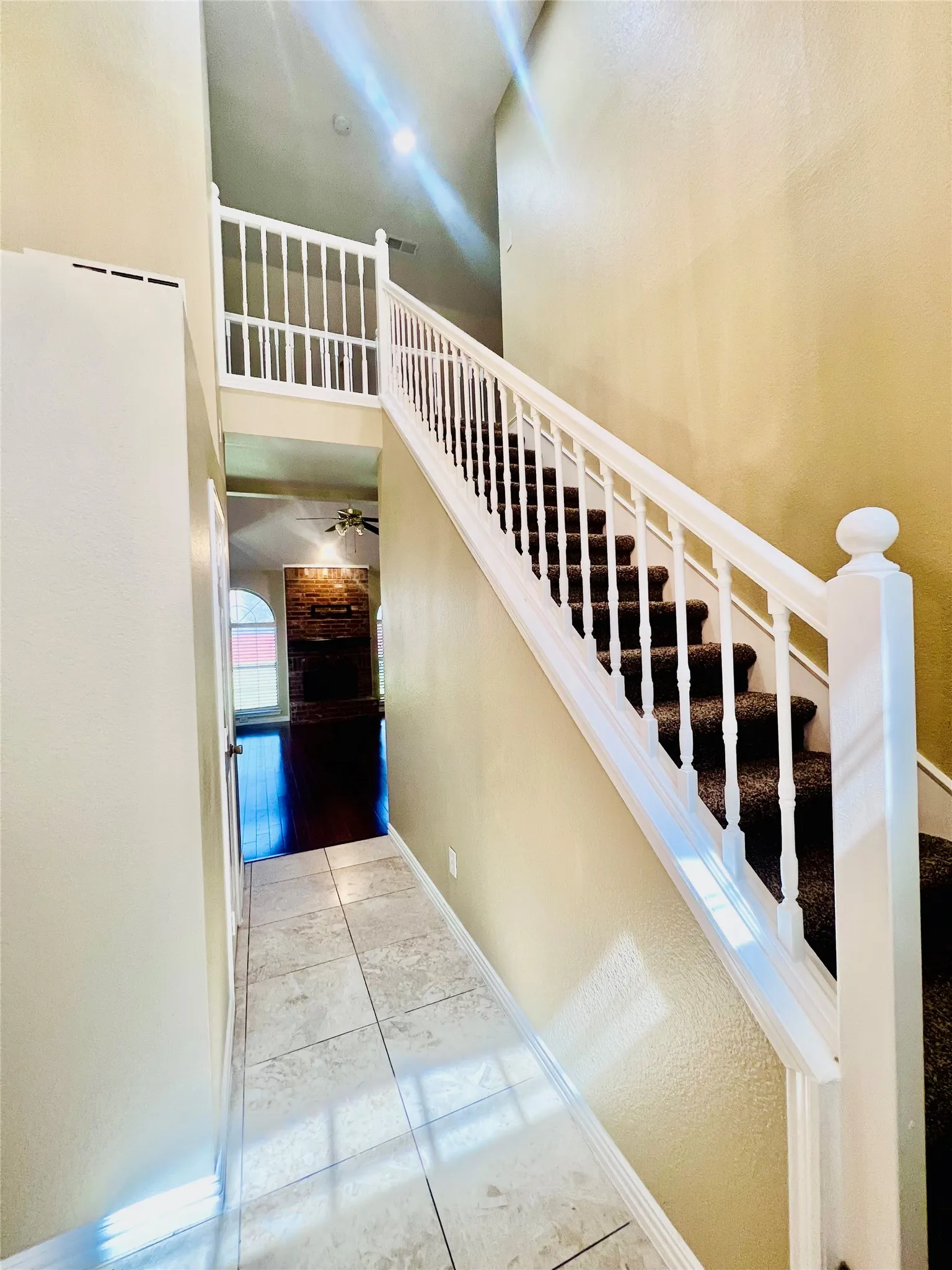 Staircase featuring a high ceiling and tile patterned flooring