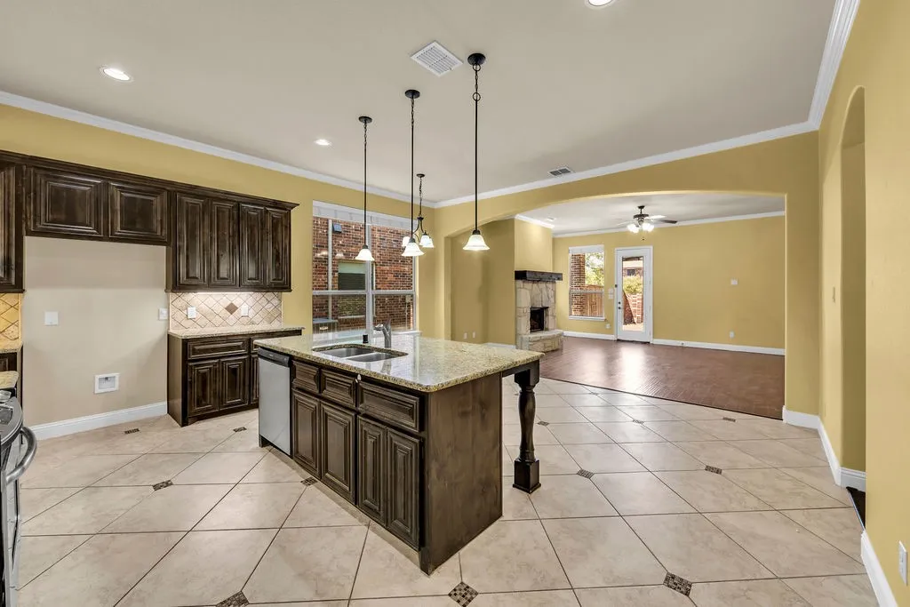 Kitchen featuring dark wood-finish cabinetry, a central island with a light-toned countertop, and recessed lighting