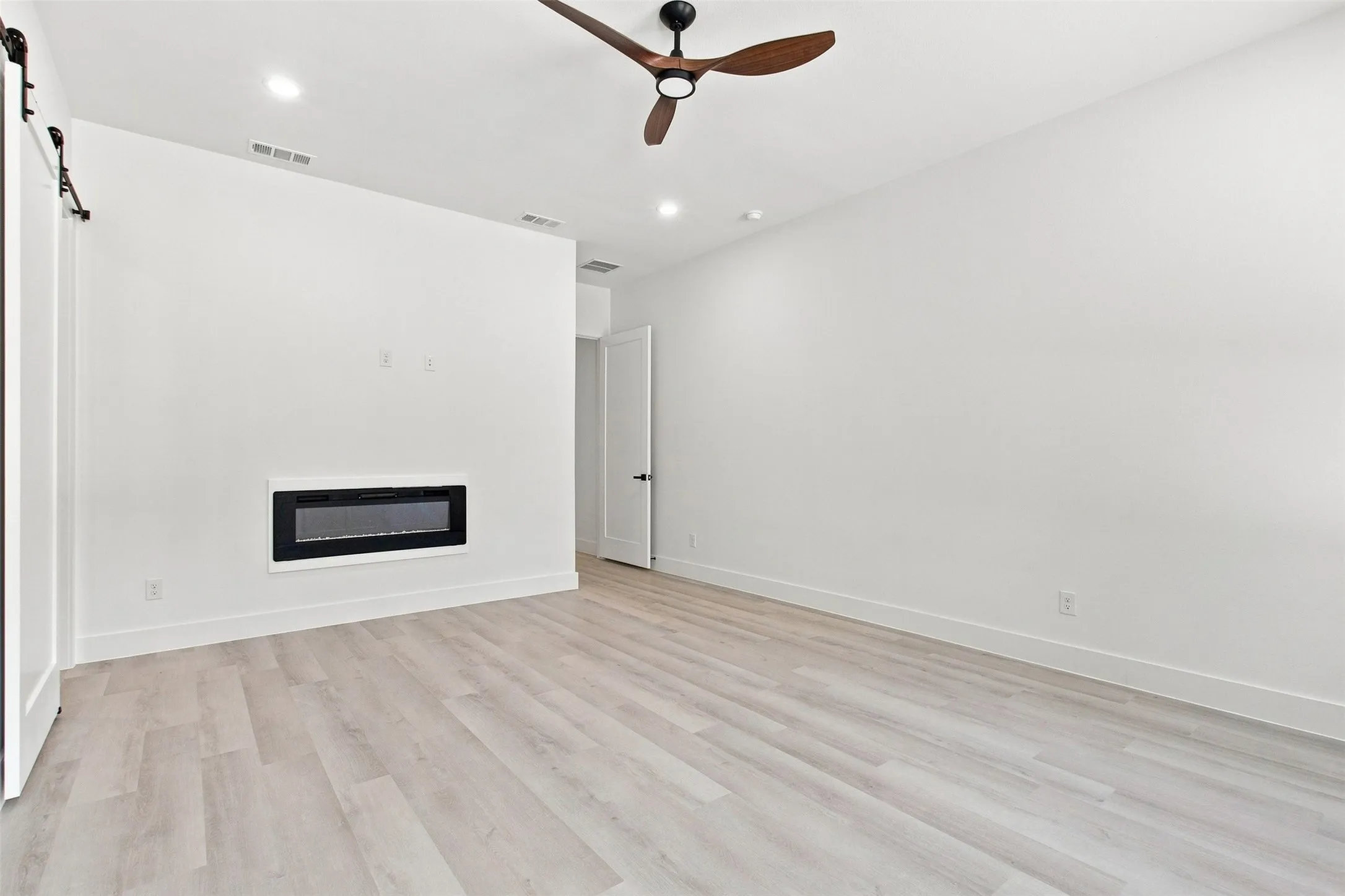 Recessed lighting and a ceiling fan with wood-finish blades