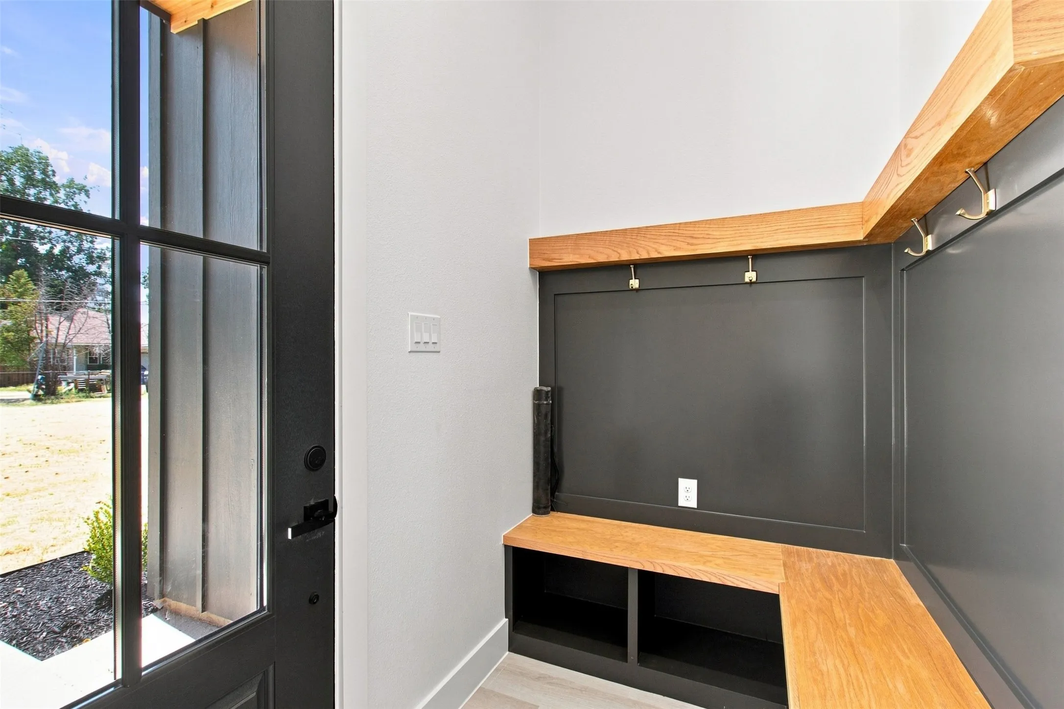Entry with built-in bench seating, storage cubbies, and wall-mounted coat hooks