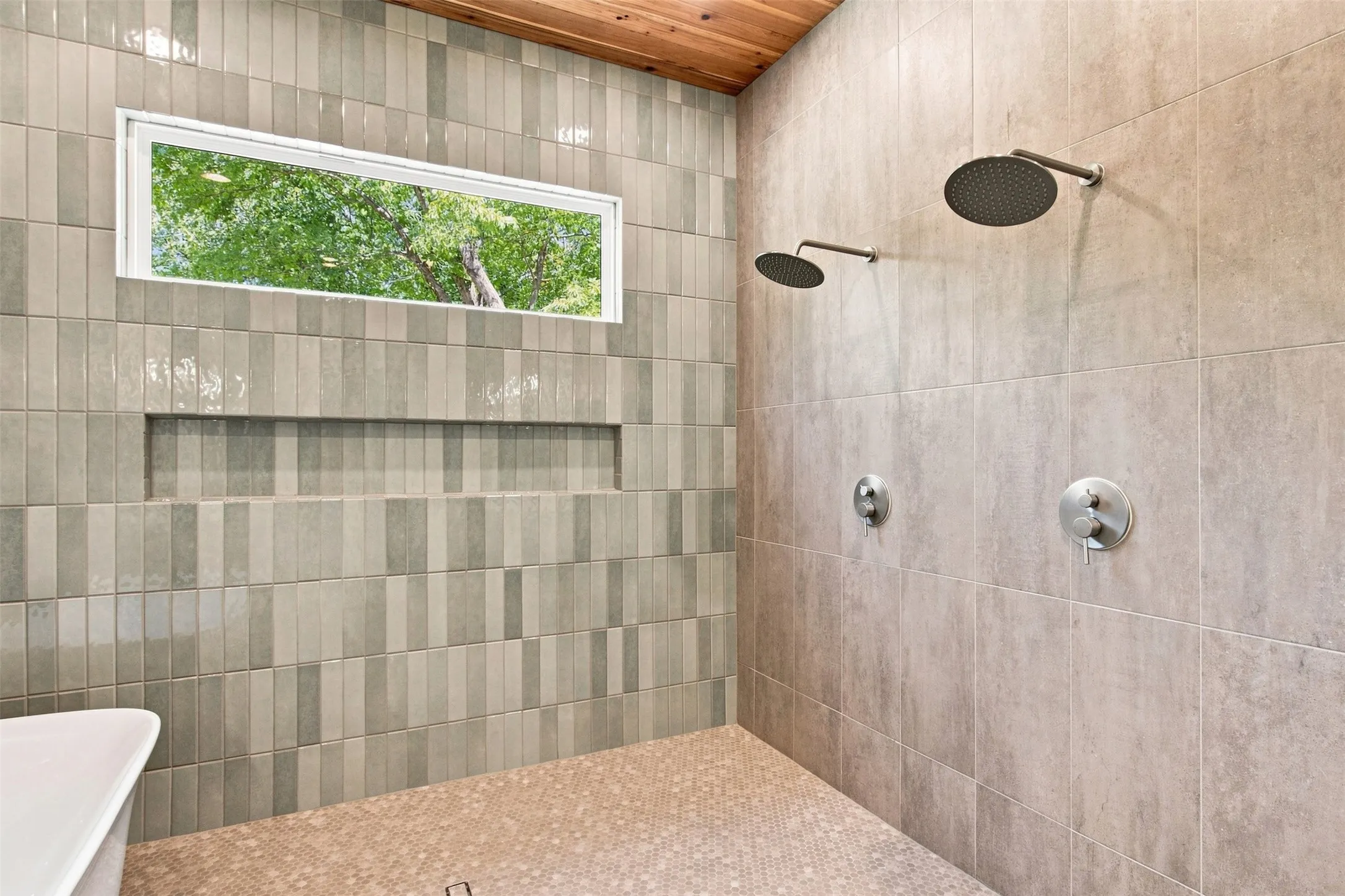 Dual rain shower heads with brushed nickel fixtures, a built-in shower niche, and a horizontal transom window
