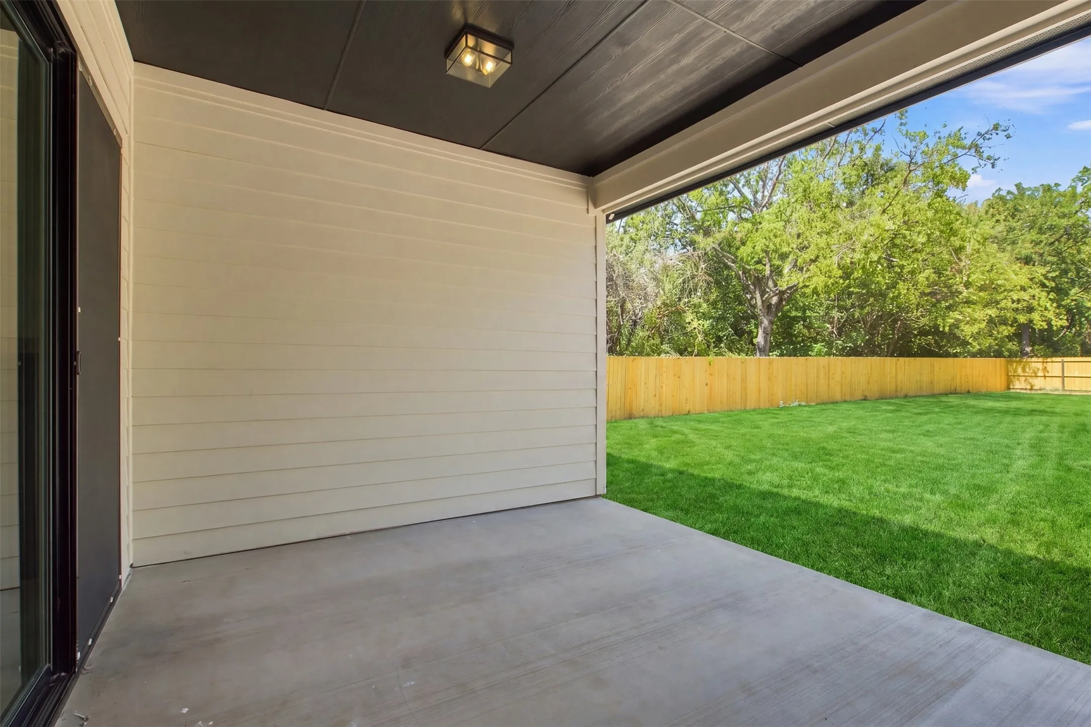 Covered patio with concrete flooring, plank siding, and integrated ceiling lighting