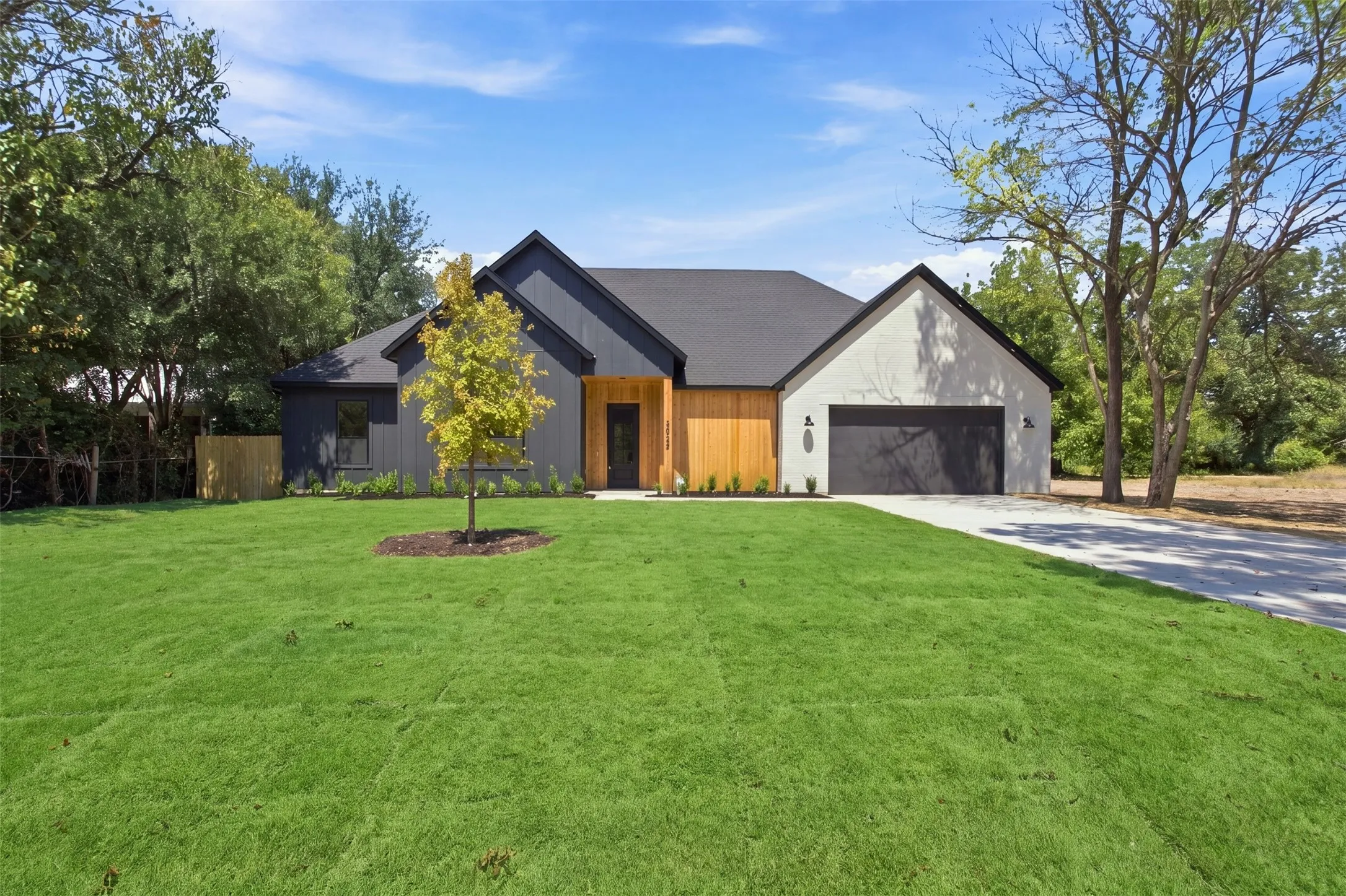 Modern exterior with a combination of dark siding, light-colored stucco, and wood paneling