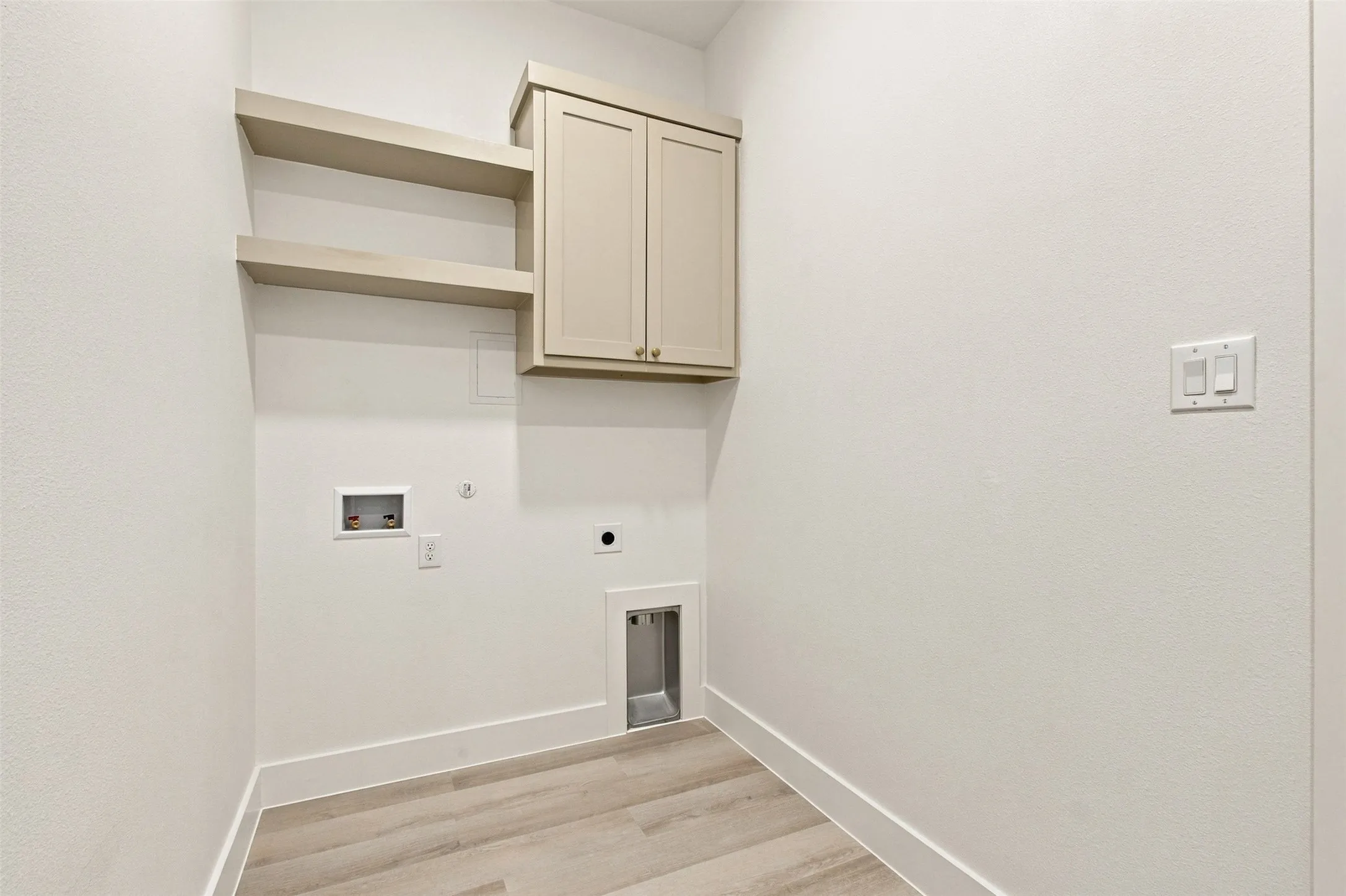 Laundry area featuring wood-finish flooring, built-in cabinetry, and integrated shelving