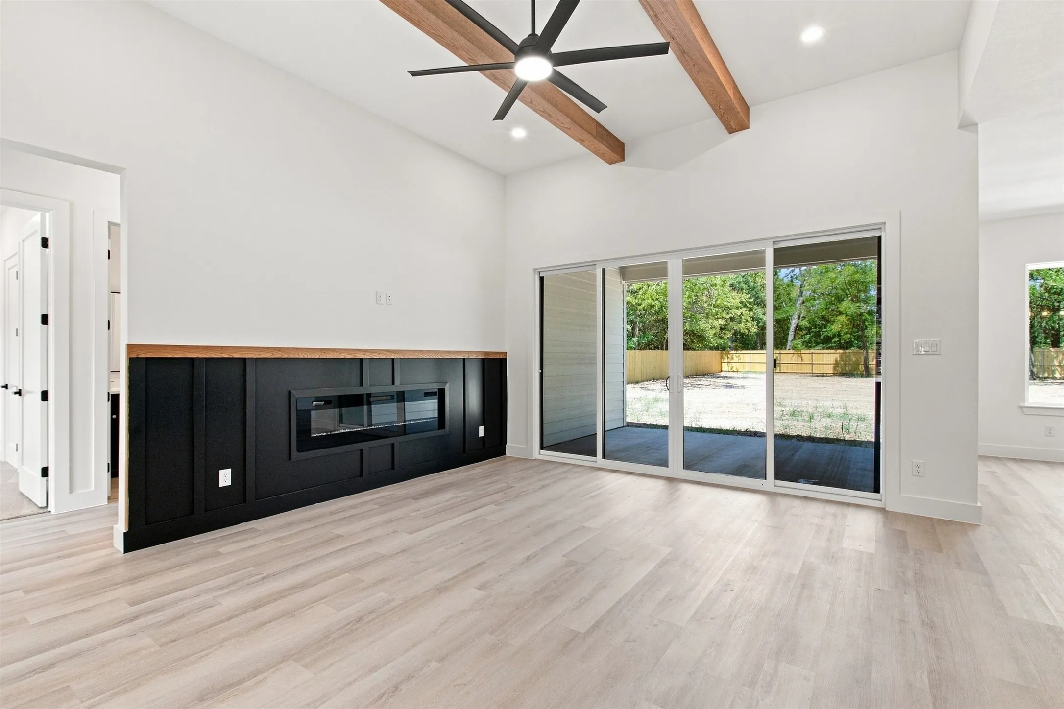 Vaulted ceilings with exposed wood beams, a contemporary ceiling fan, and recessed lighting