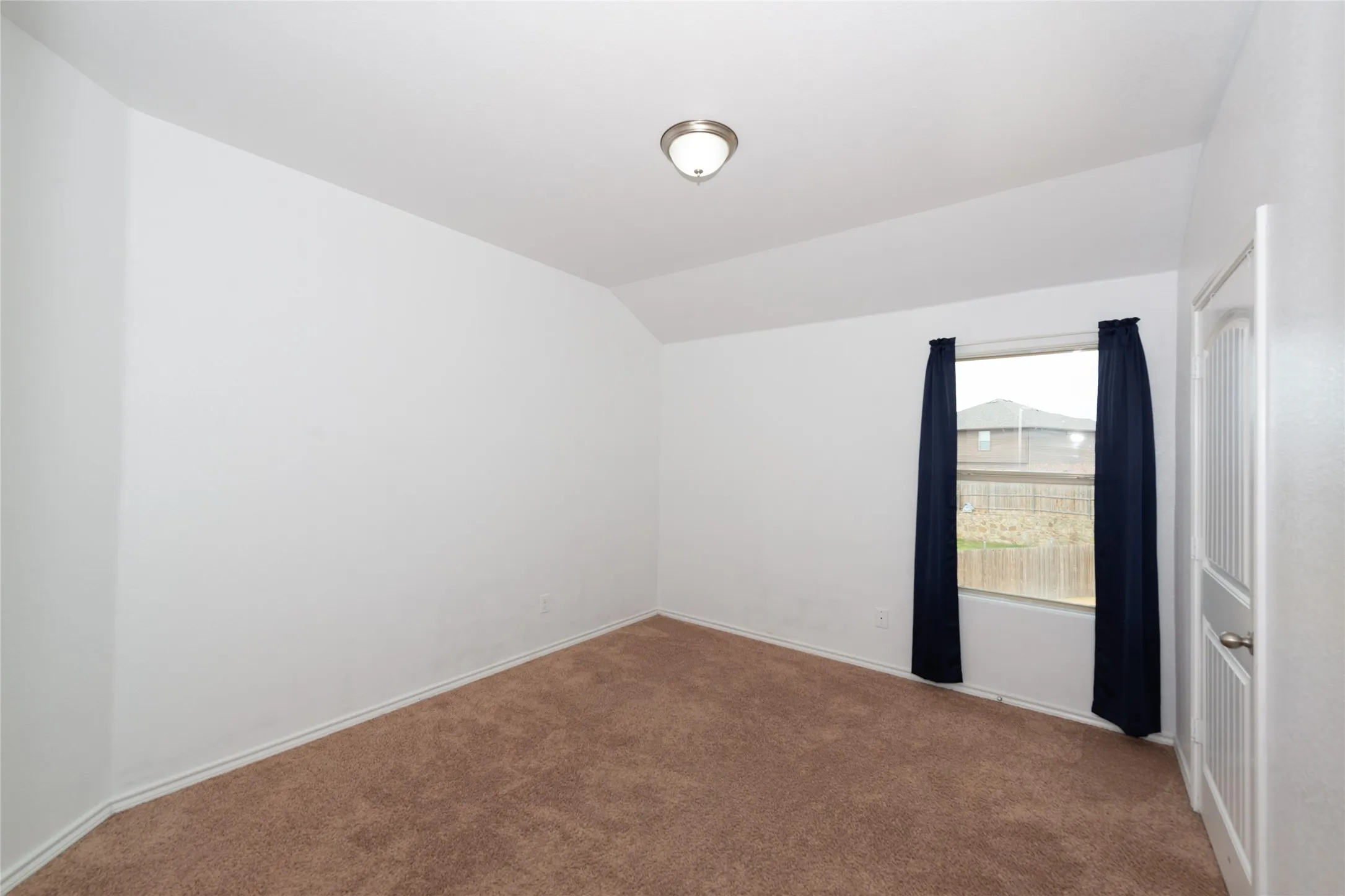 Neutral paint palette, textured carpet, and a flush-mount ceiling light fixture