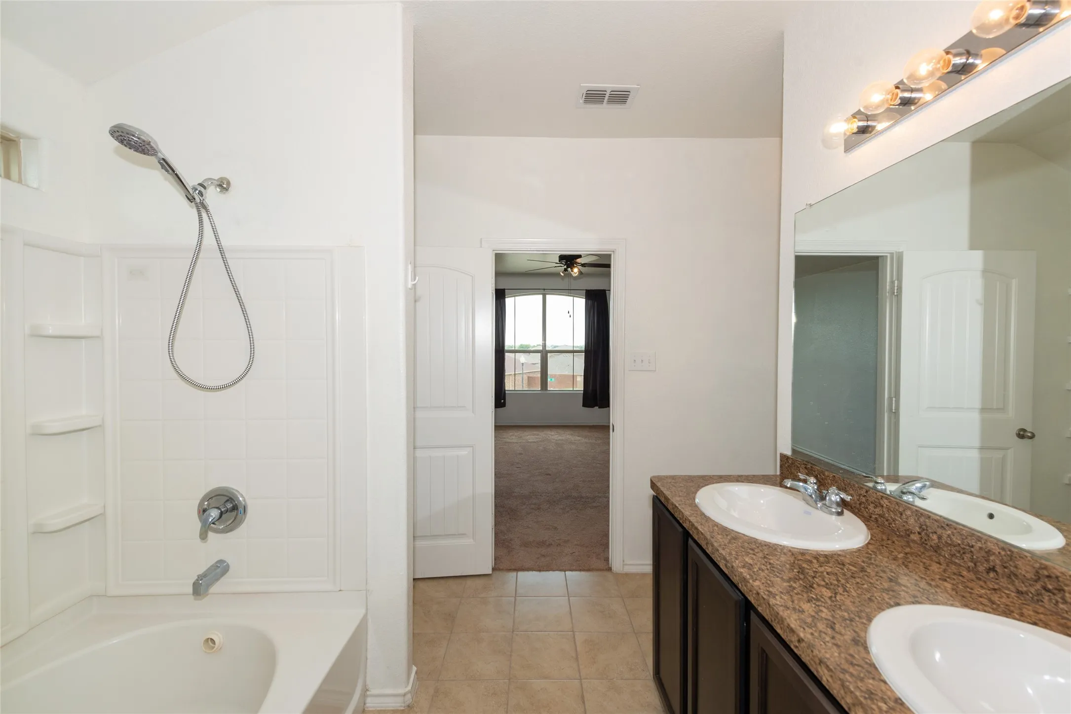 Dual vanity with integrated sinks, spacious mirror, and overhead lighting