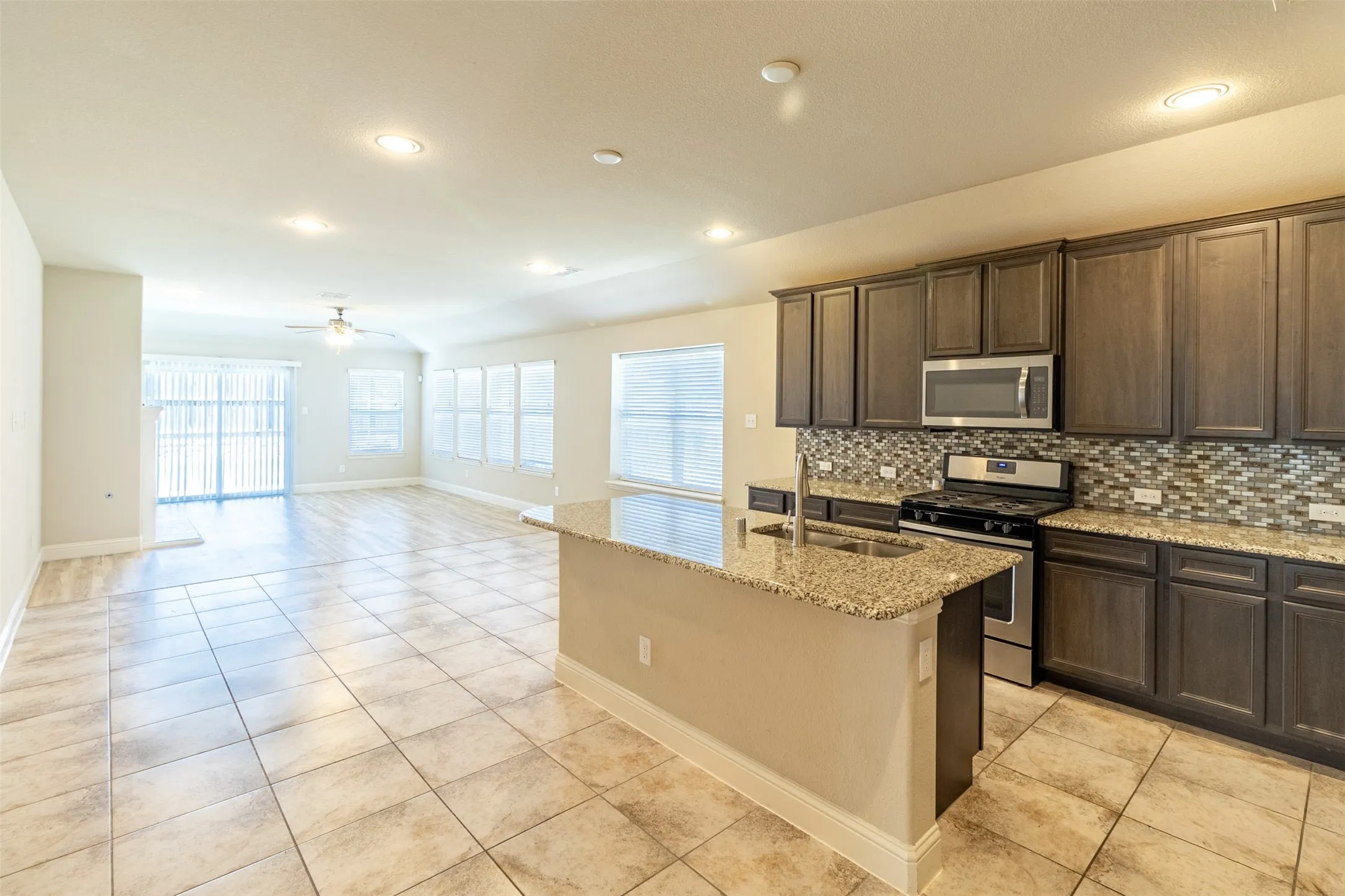 Open-concept living area with tile flooring and recessed lighting