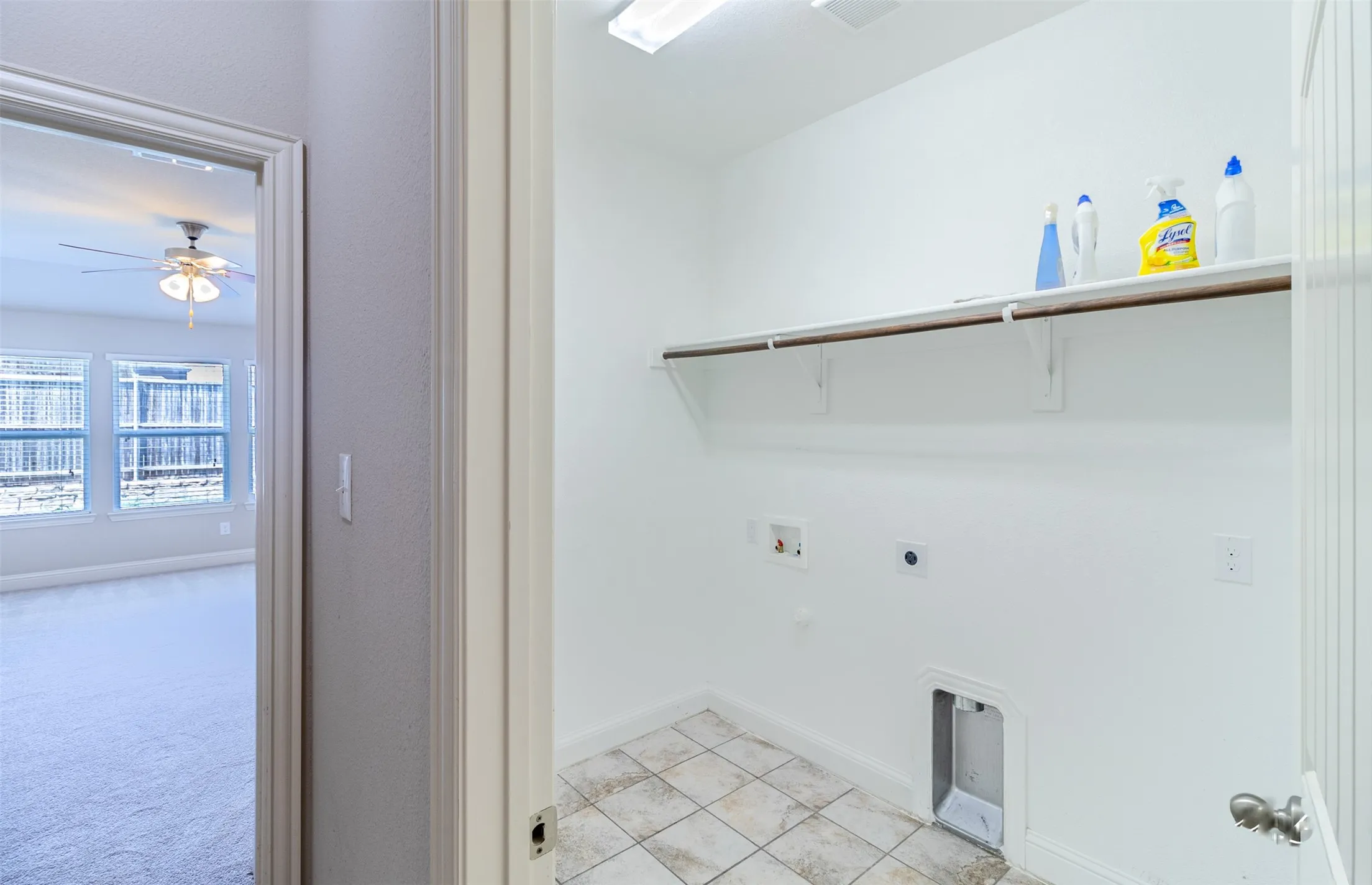Laundry area with tiled flooring, wall-mounted shelving, and appliance hookups