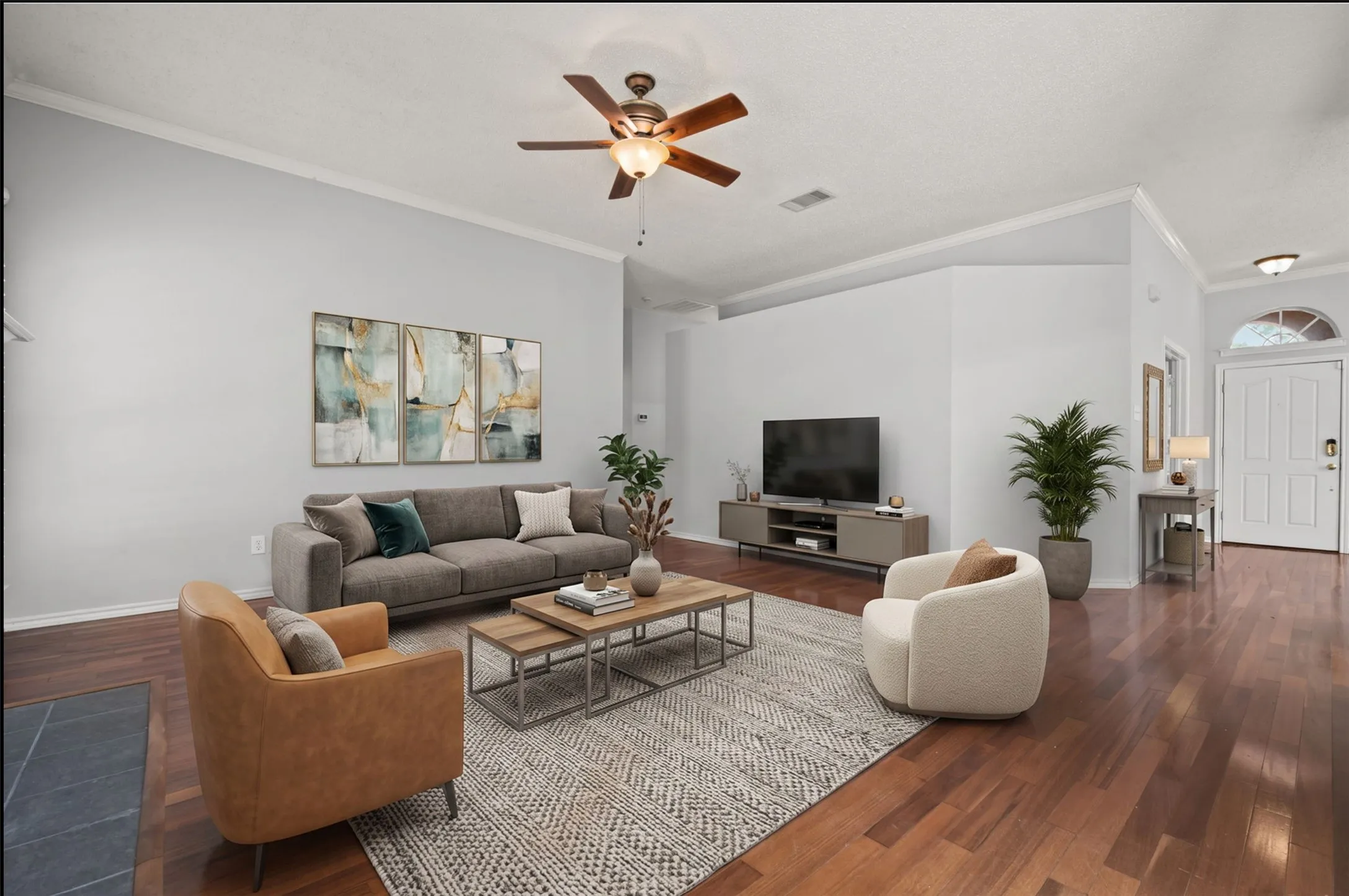 High ceilings, crown molding, wood flooring, ceiling fan, and an arched entry door