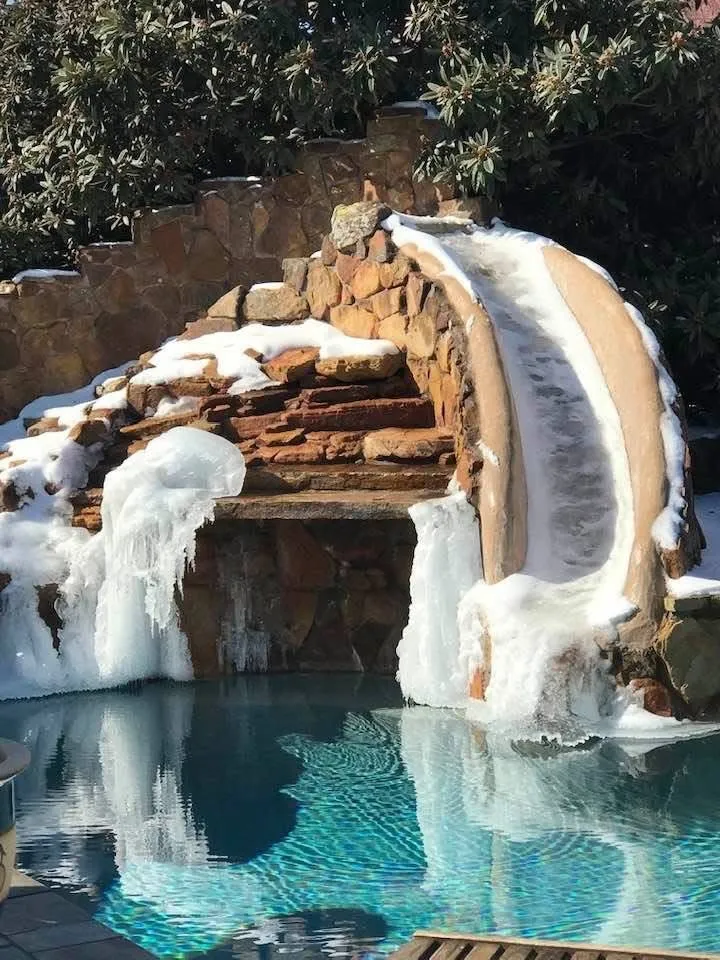 Pool area featuring rock-faced features, a built-in slide, seating inside grotto are to excape the sun or enjoy the waterfall from behind. Mature landscaping. Fruit bearing loquat tree in area behind slide supplies shade as well as additional privacy.
Continue to enjoy your heated pool and spa even on our few cold Texas days!